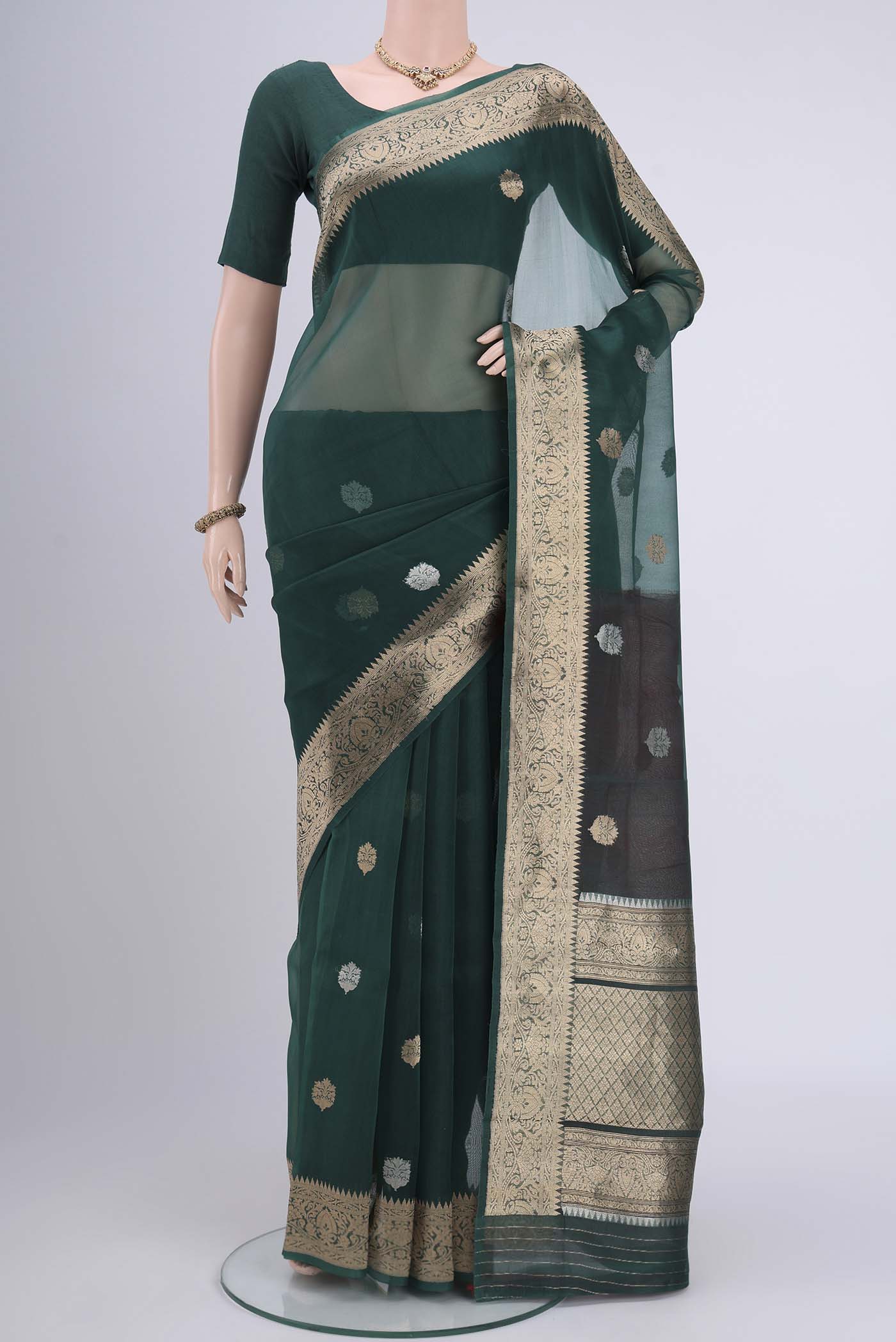 Bottle Green Organza Silk Saree with Plain Body and Zari Border.  displayed on a mannequin