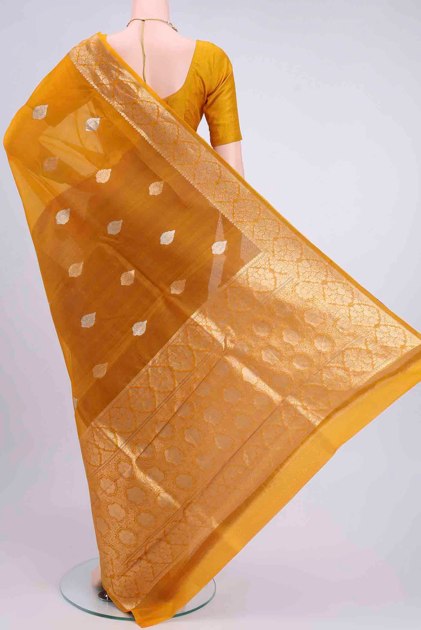 Flat view of Mustard Organza Silk Saree with Zari Butta on the body and Zari Border