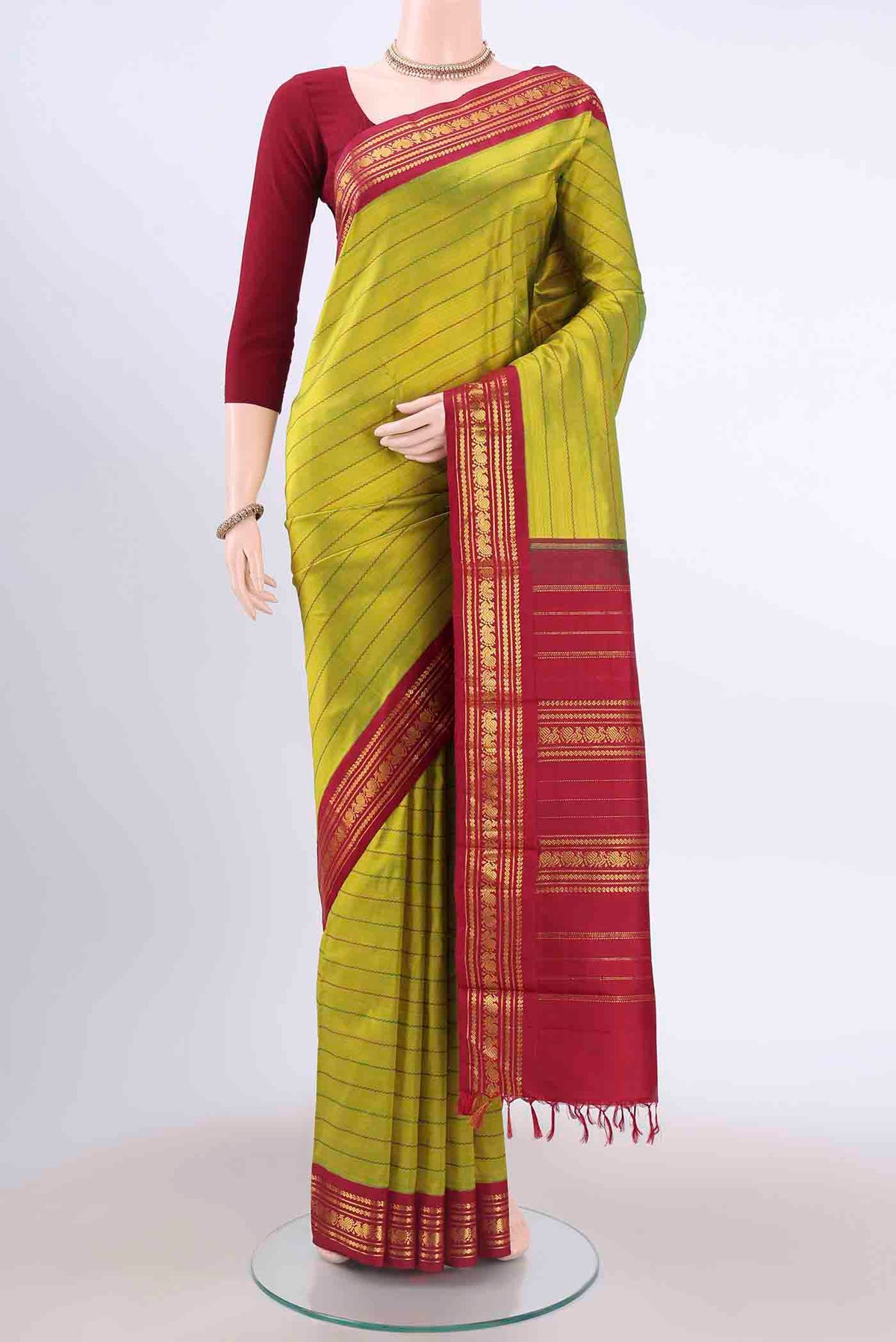 Light Green Kanchipuram Silk Saree with Stripes on the body and Zari Border displayed on a mannequin