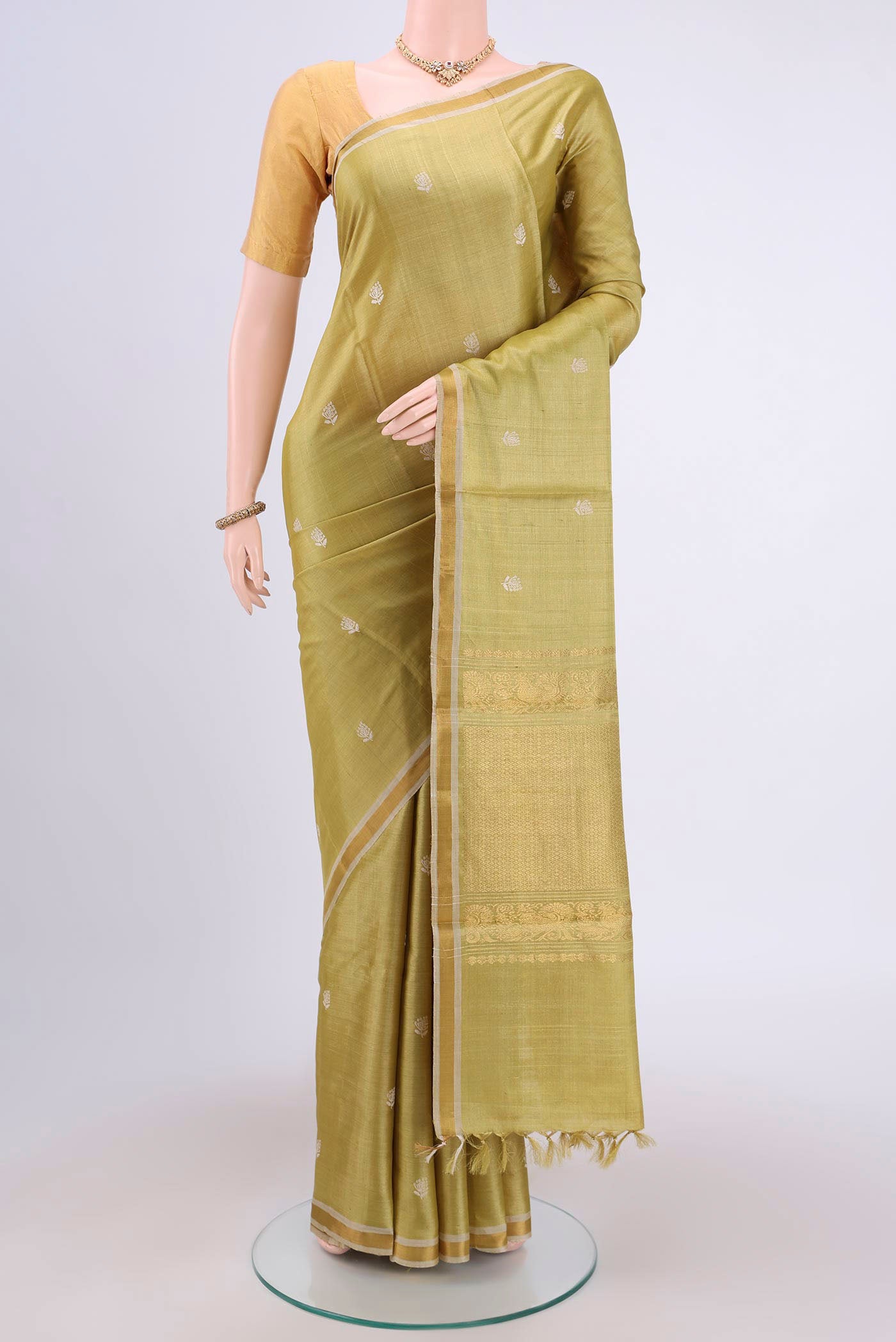 Sage Green Tussar Silk Saree with Zari Butta on the body and Zari Border.  displayed on a mannequin