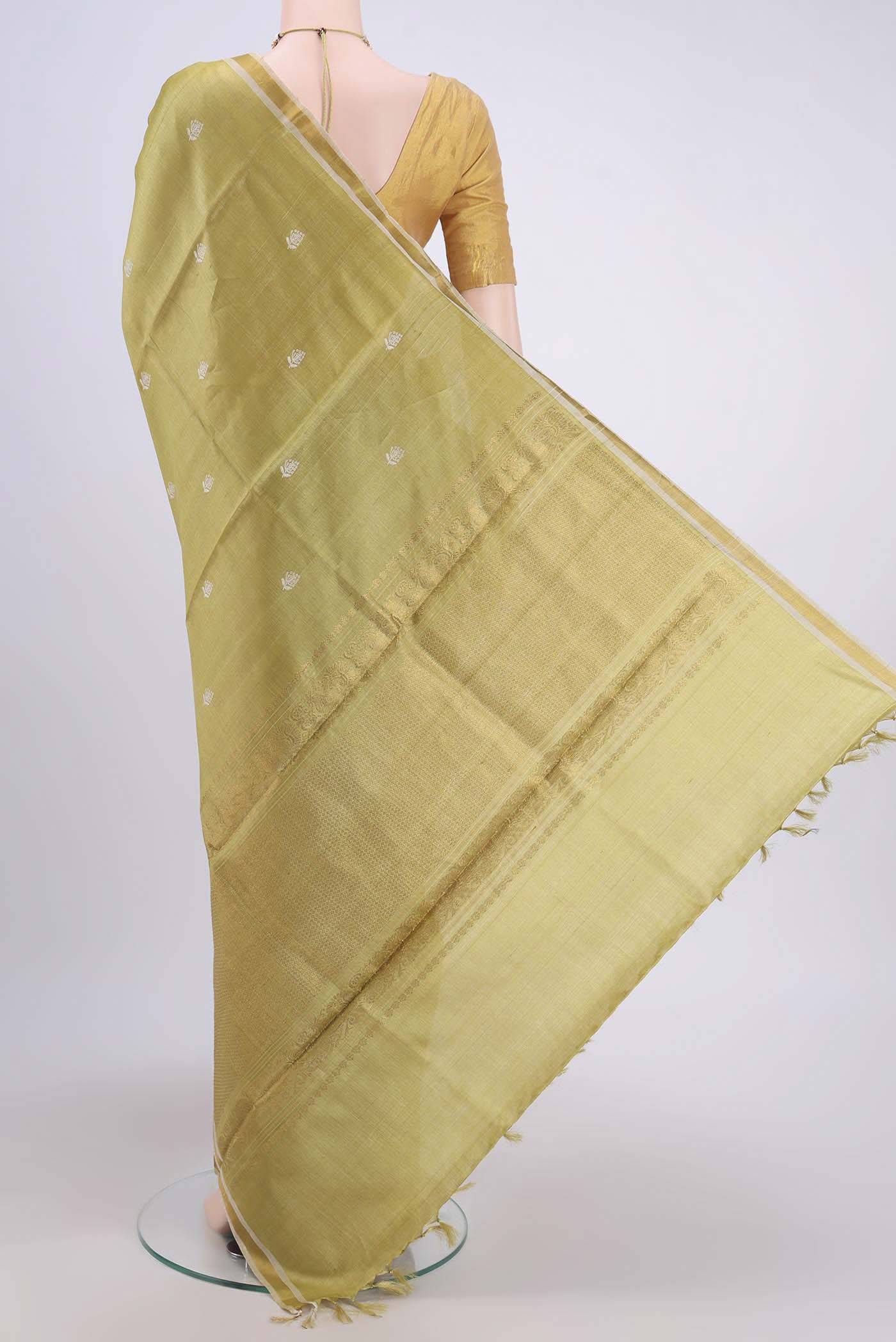 Flat view of Sage Green Tussar Silk Saree with Zari Butta on the body and Zari Border. 