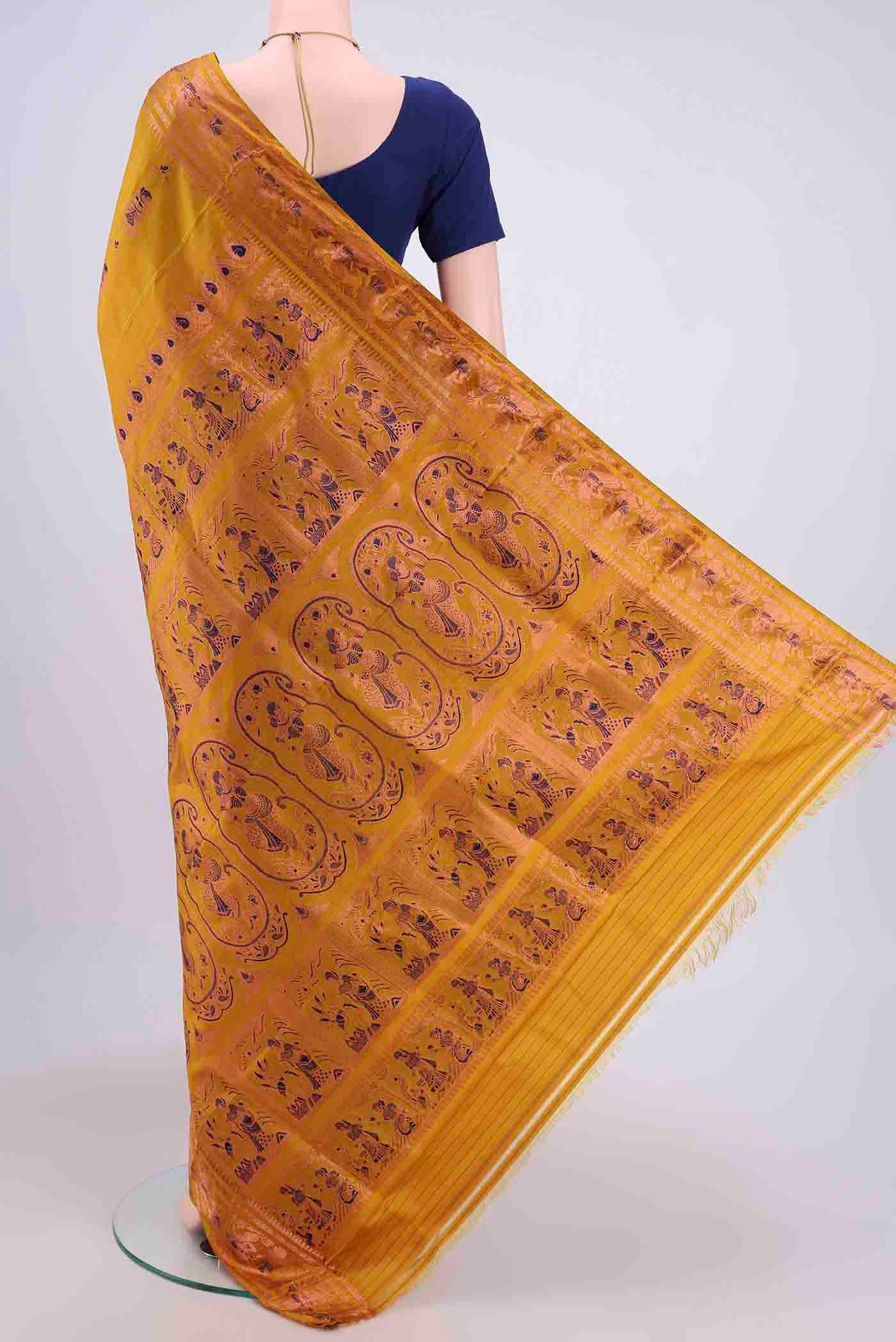 Flat view of Mustard Dual Tone Baluchari Silk Saree with Zari And Thread Butta on the body and Zari Border. 