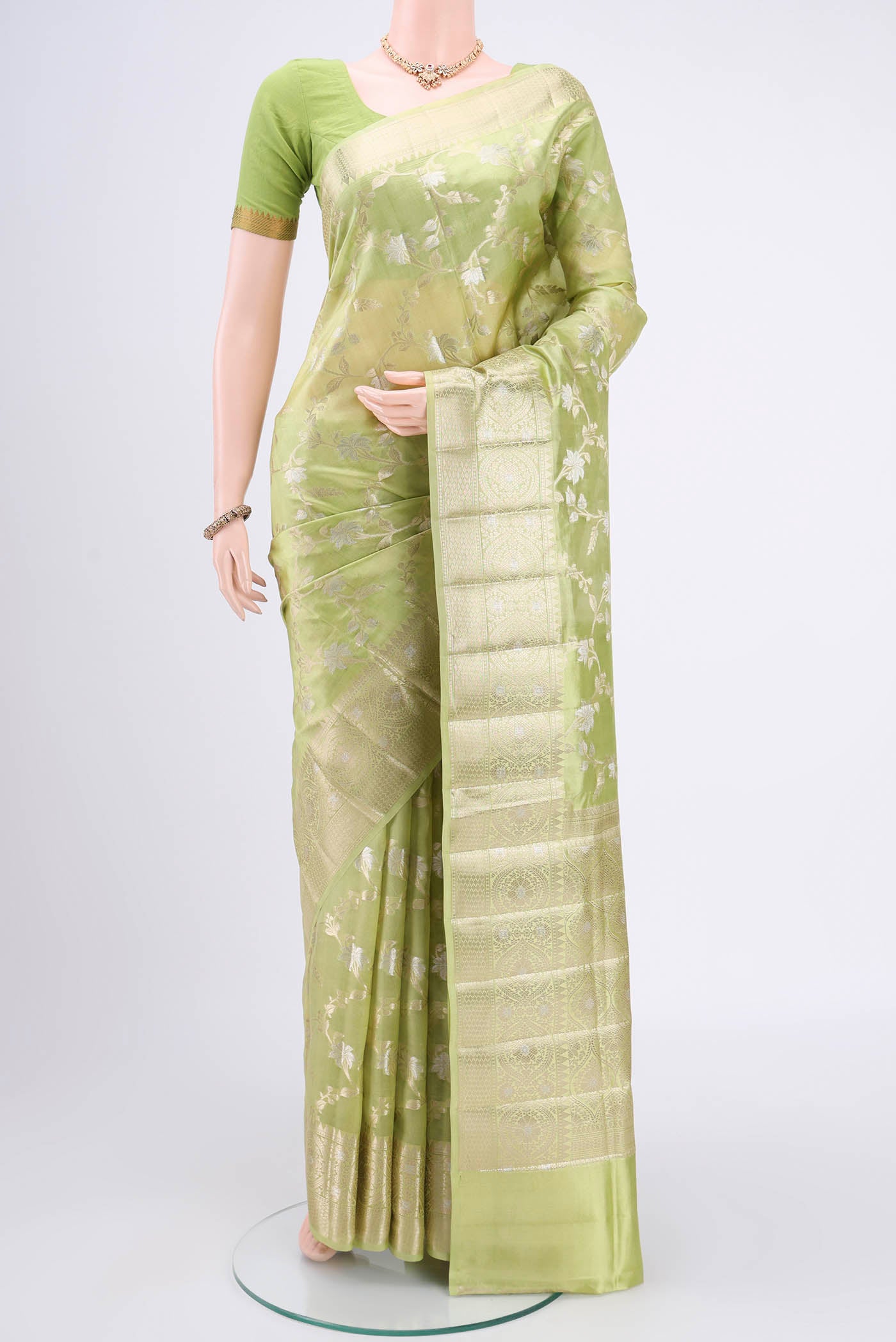Light Green Banarasi Raw Silk Saree with Zari Butta on the body and Zari Border.  displayed on a mannequin