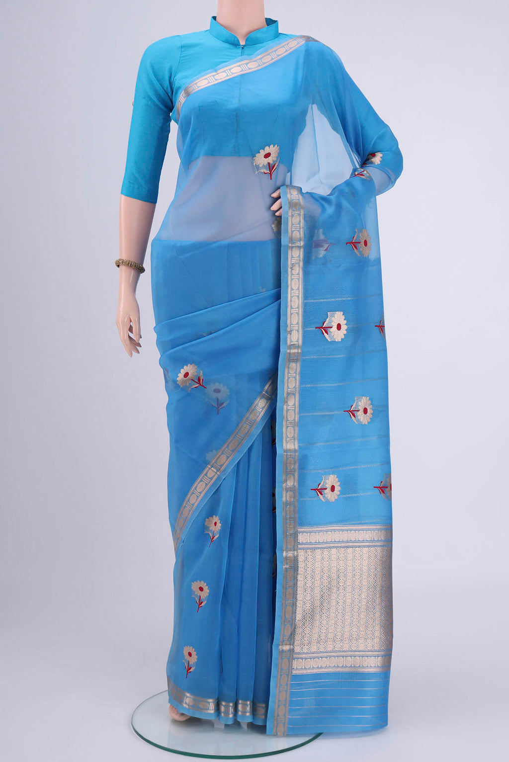 Blue Organza Silk Saree with Zari Butta on the body and Zari Border.  displayed on a mannequin