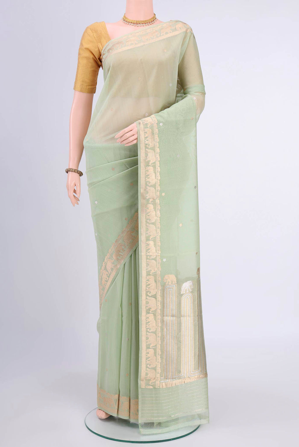 Mint Green Organza Silk Saree with Zari Butta on the body and Zari Border displayed on a mannequin