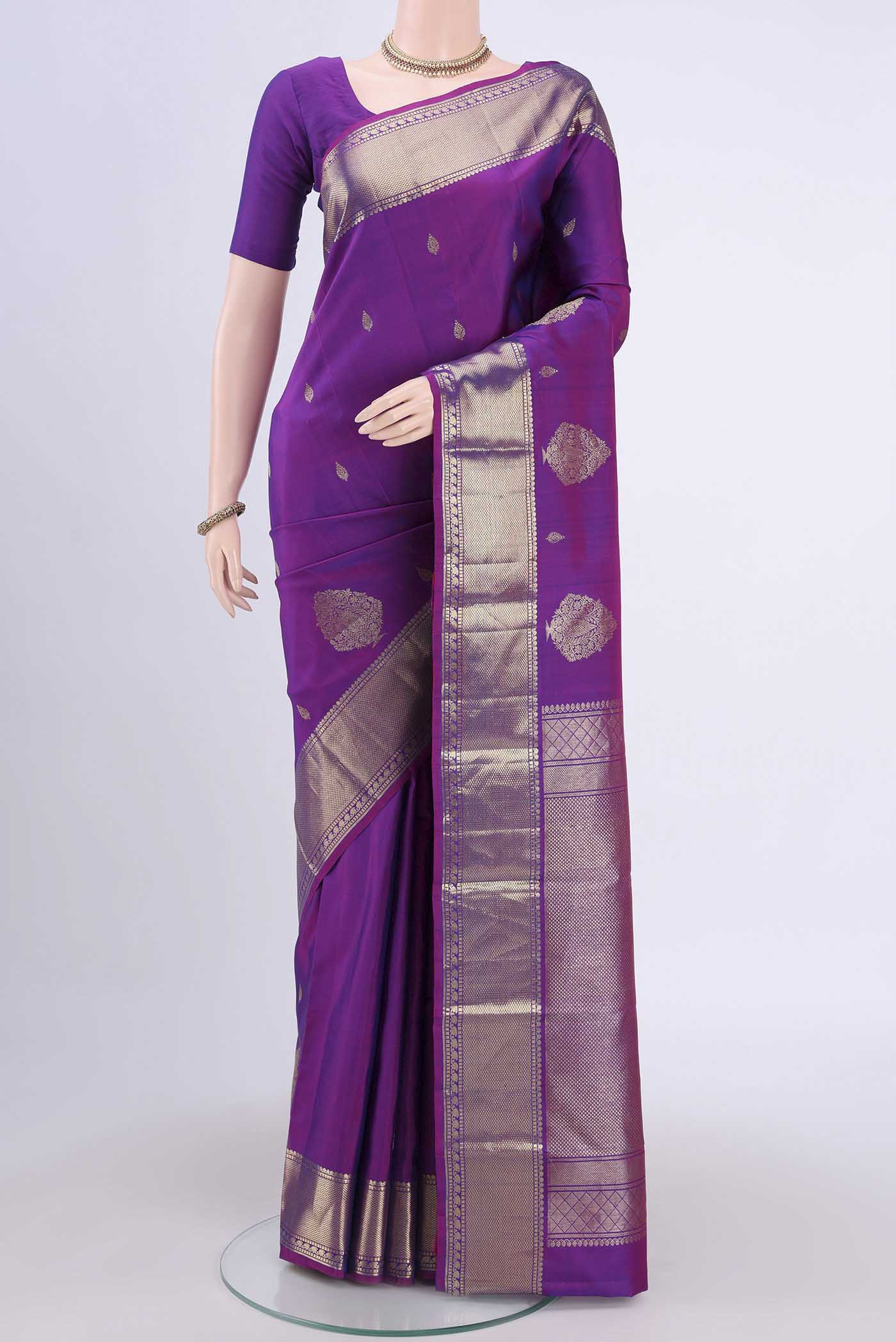 Magenta Kanchipuram Saree with Zari Butta on the body and Zari Border.  displayed on a mannequin