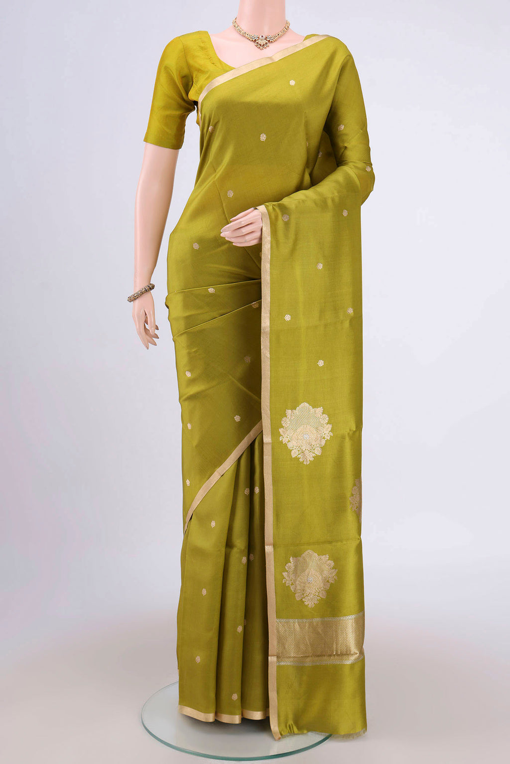 Parrot Green Banarasi Katan Silk Saree with Zari Butta on the body and Zari Border.  displayed on a mannequin