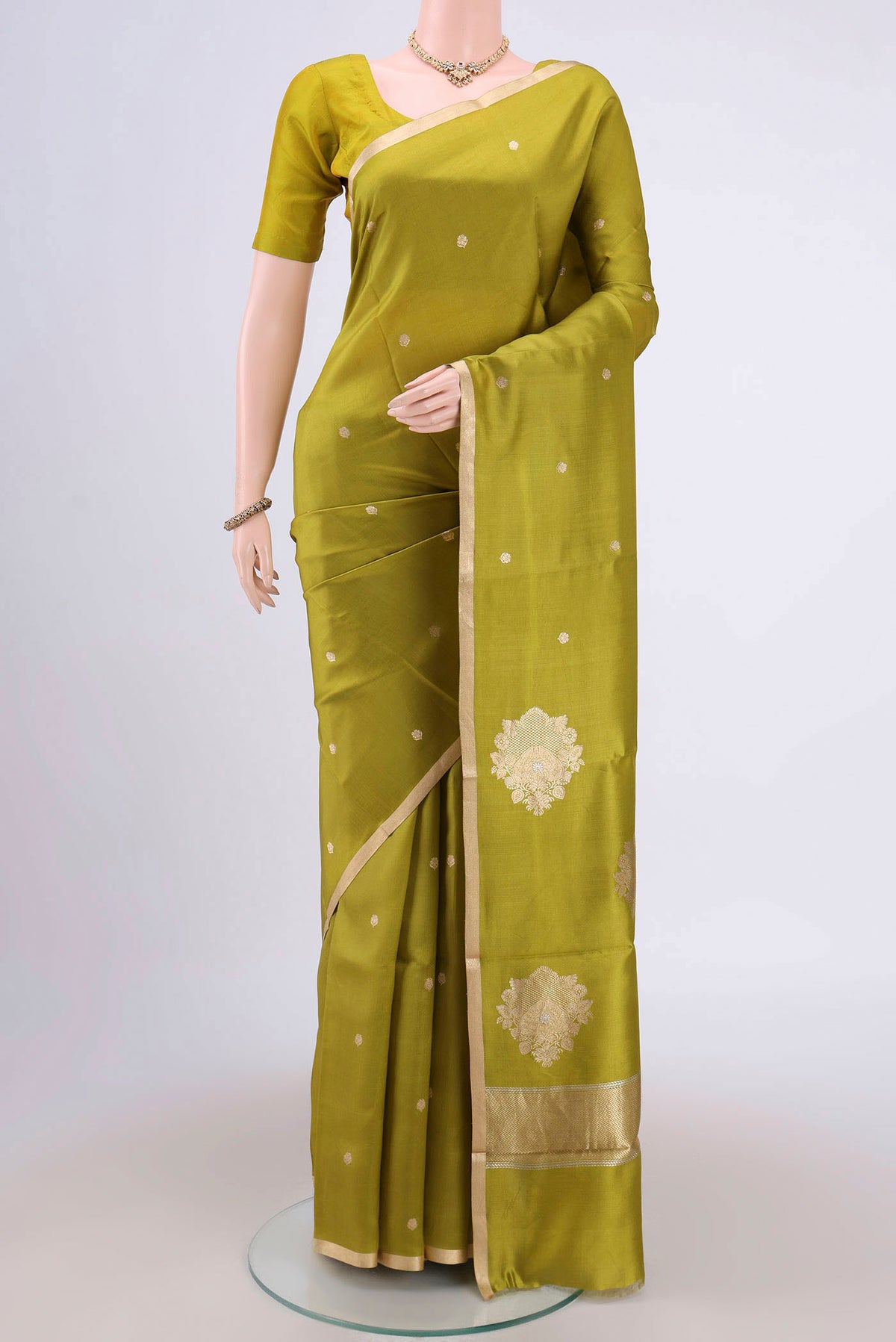 Parrot Green Banarasi Katan Silk Saree with Zari Butta on the body and Zari Border.  displayed on a mannequin