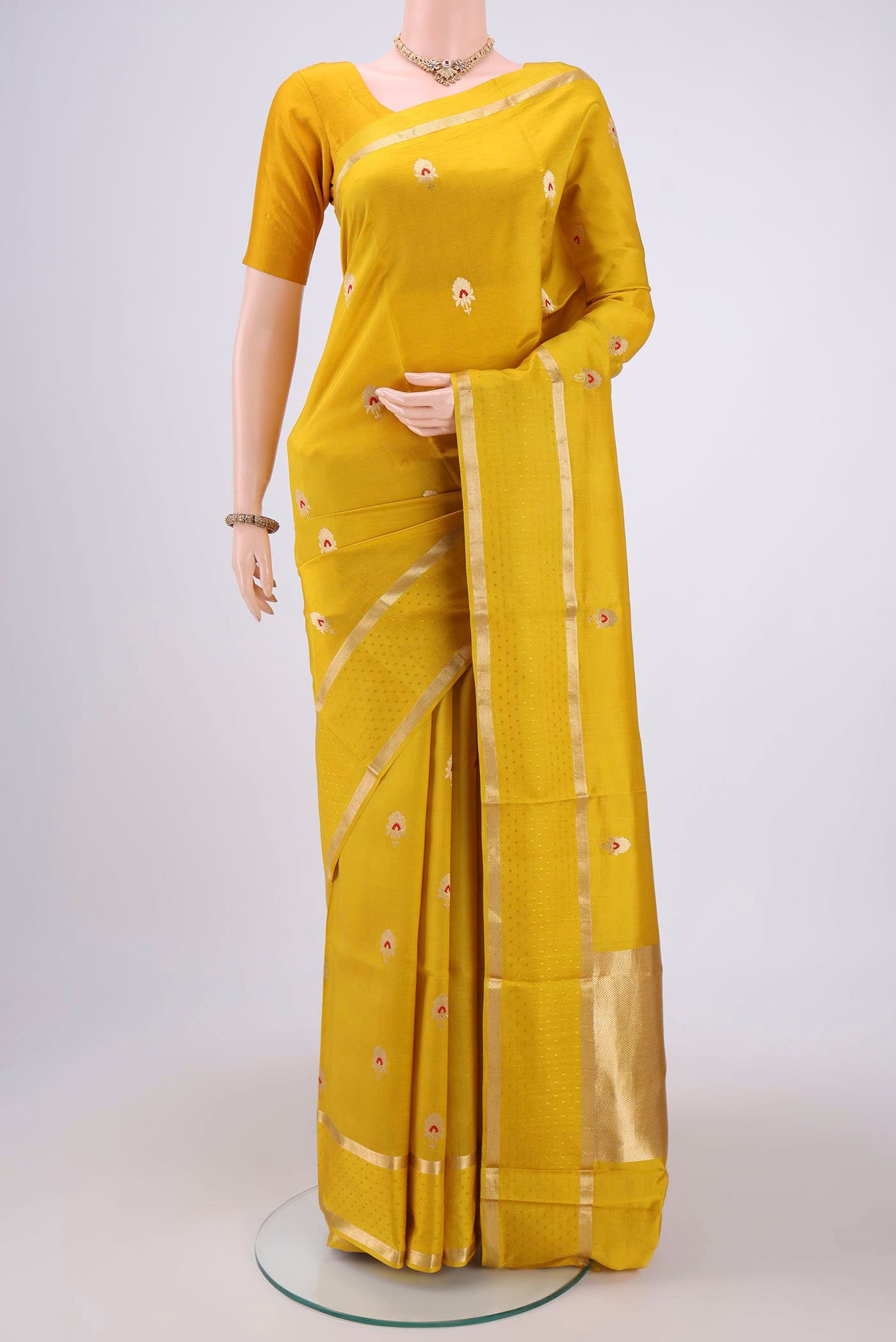 Yellow Banarasi Saree with Zari Butta on the body and Zari Border.  displayed on a mannequin