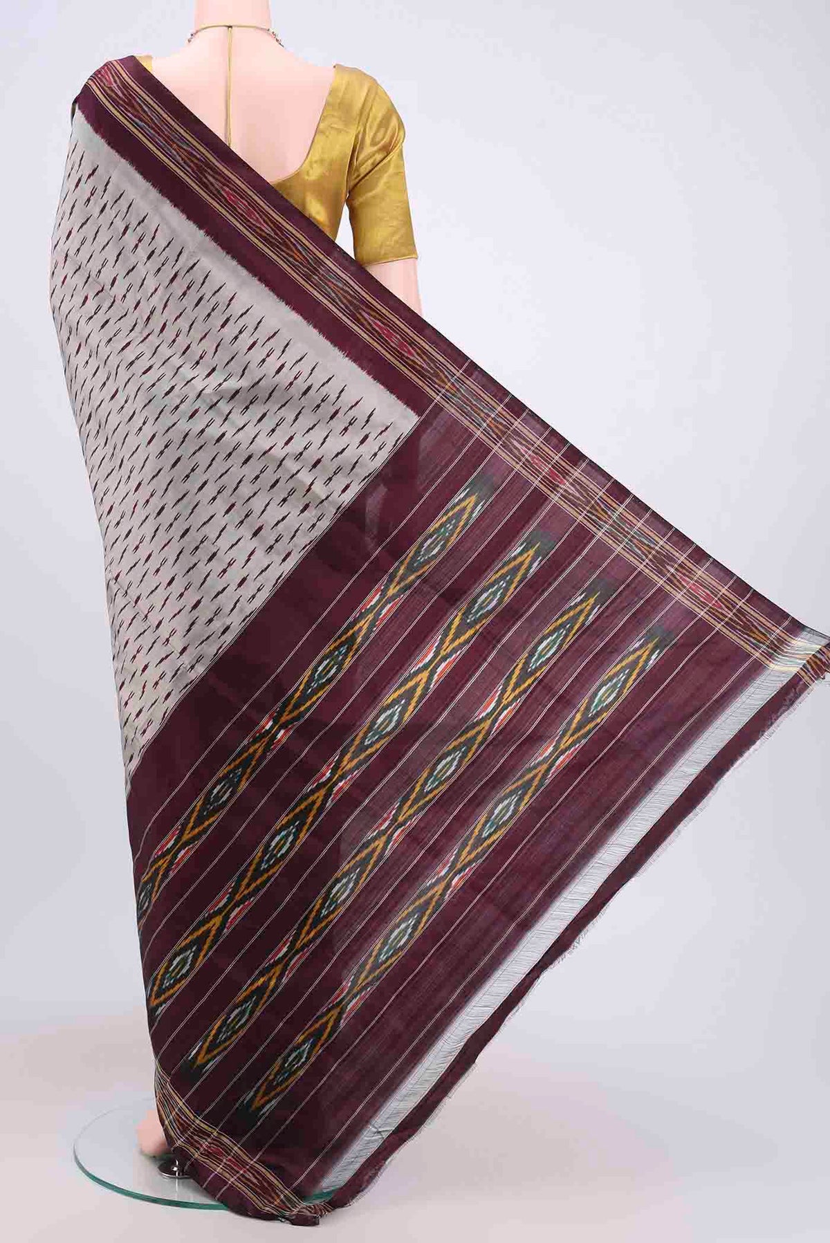 Flat view of Silver Pochampally Silk Saree with Ikat design on the body and Zari Border. 