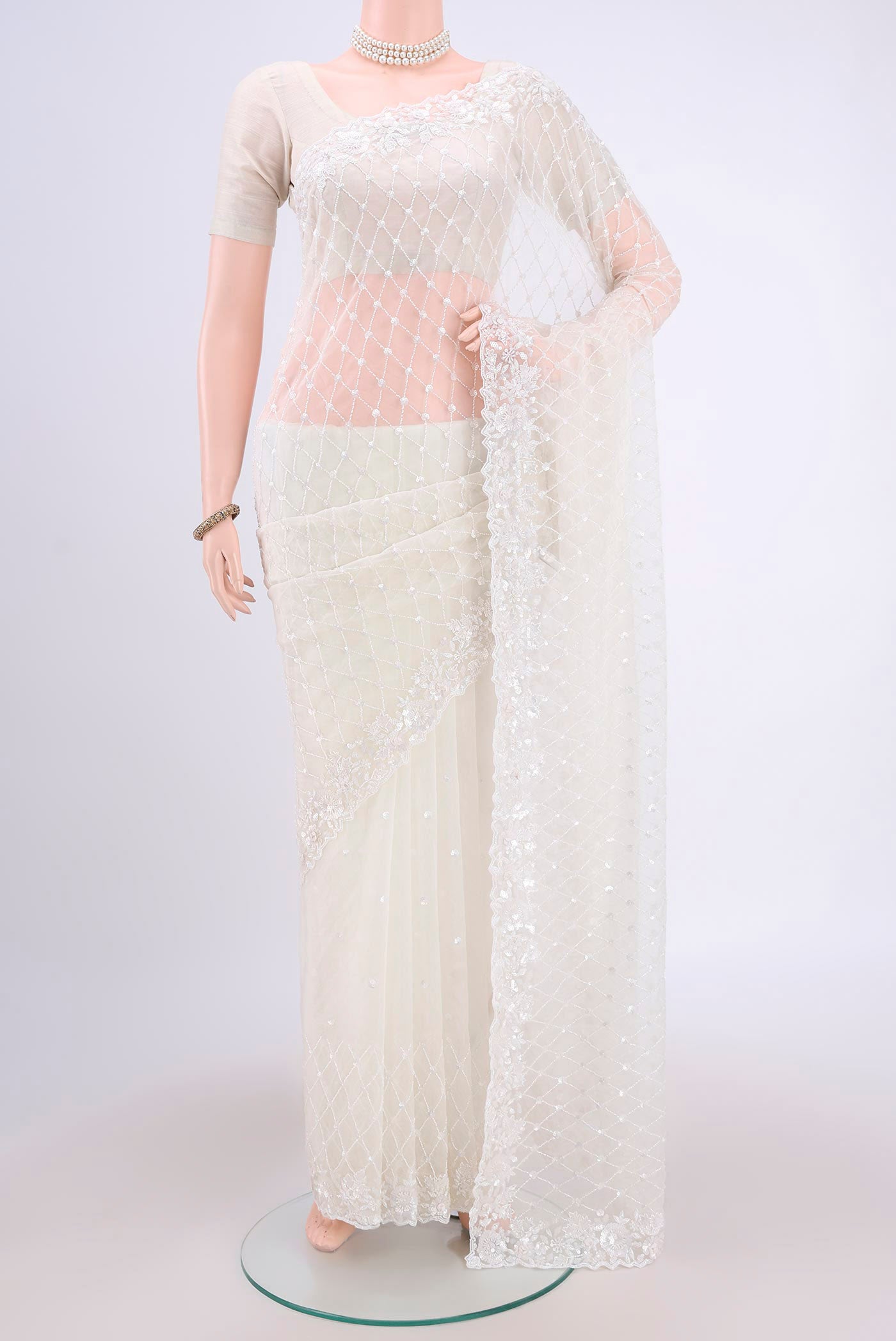 White Organza Silk Saree with Embroidery on the body and Zari Border.  displayed on a mannequin