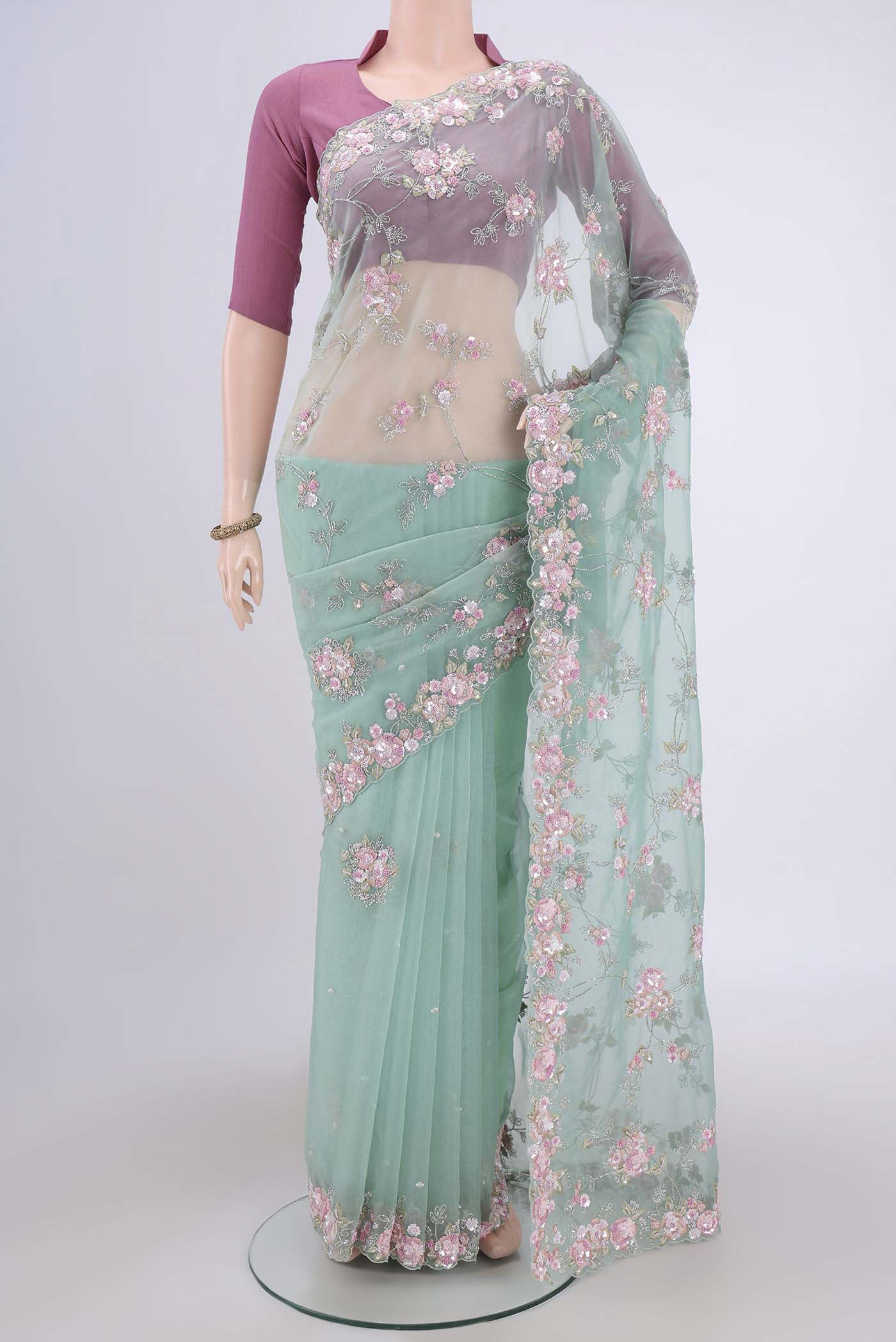 Mint Green Organza Silk Saree with Embroidery on the body and Embroidery Border.  displayed on a mannequin
