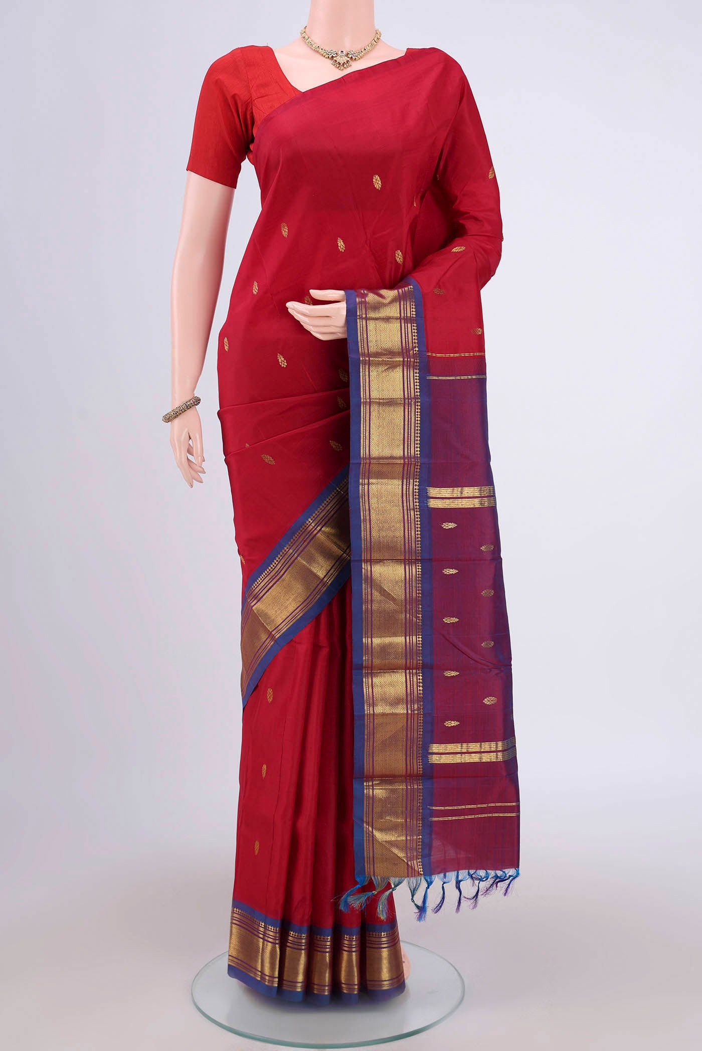 Maroon Kanjivaram Silk Saree with Zari Butta on the body and One Side Border.  displayed on a mannequin