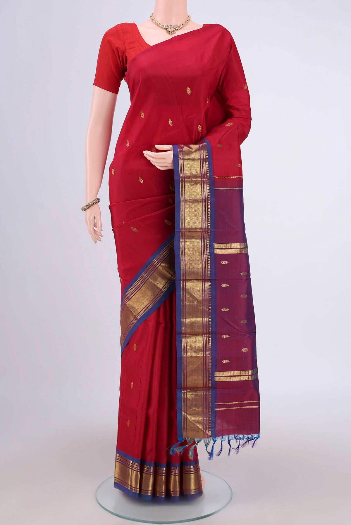 Maroon Kanjivaram Silk Saree with Zari Butta on the body and One Side Border.  displayed on a mannequin
