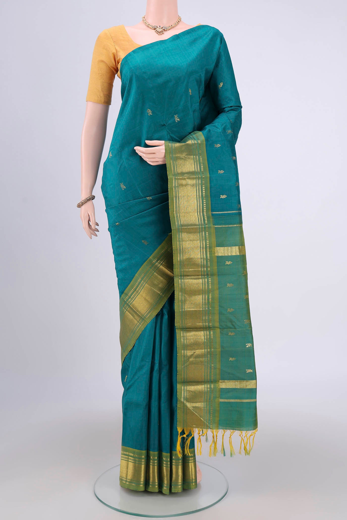 Sea Green Kanjivaram Silk Saree with Zari Butta on the body and One Side Border.  displayed on a mannequin