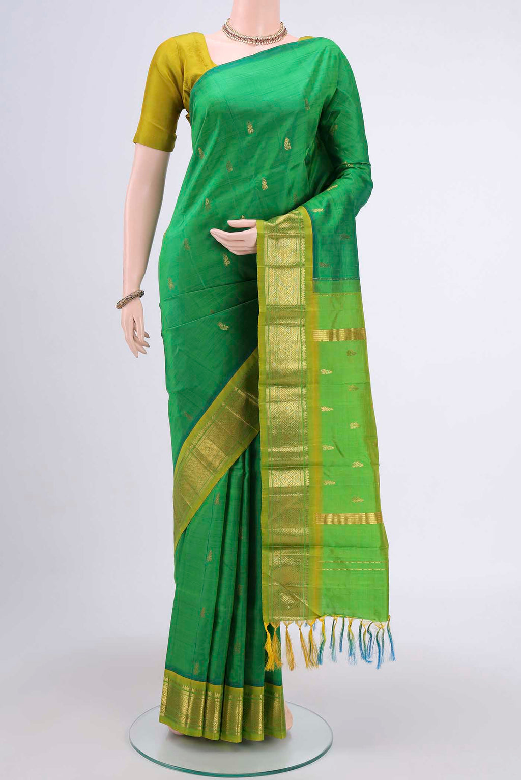 Green Kanchipuram Silk Saree with Zari Butta on the body and One Side Border displayed on a mannequin