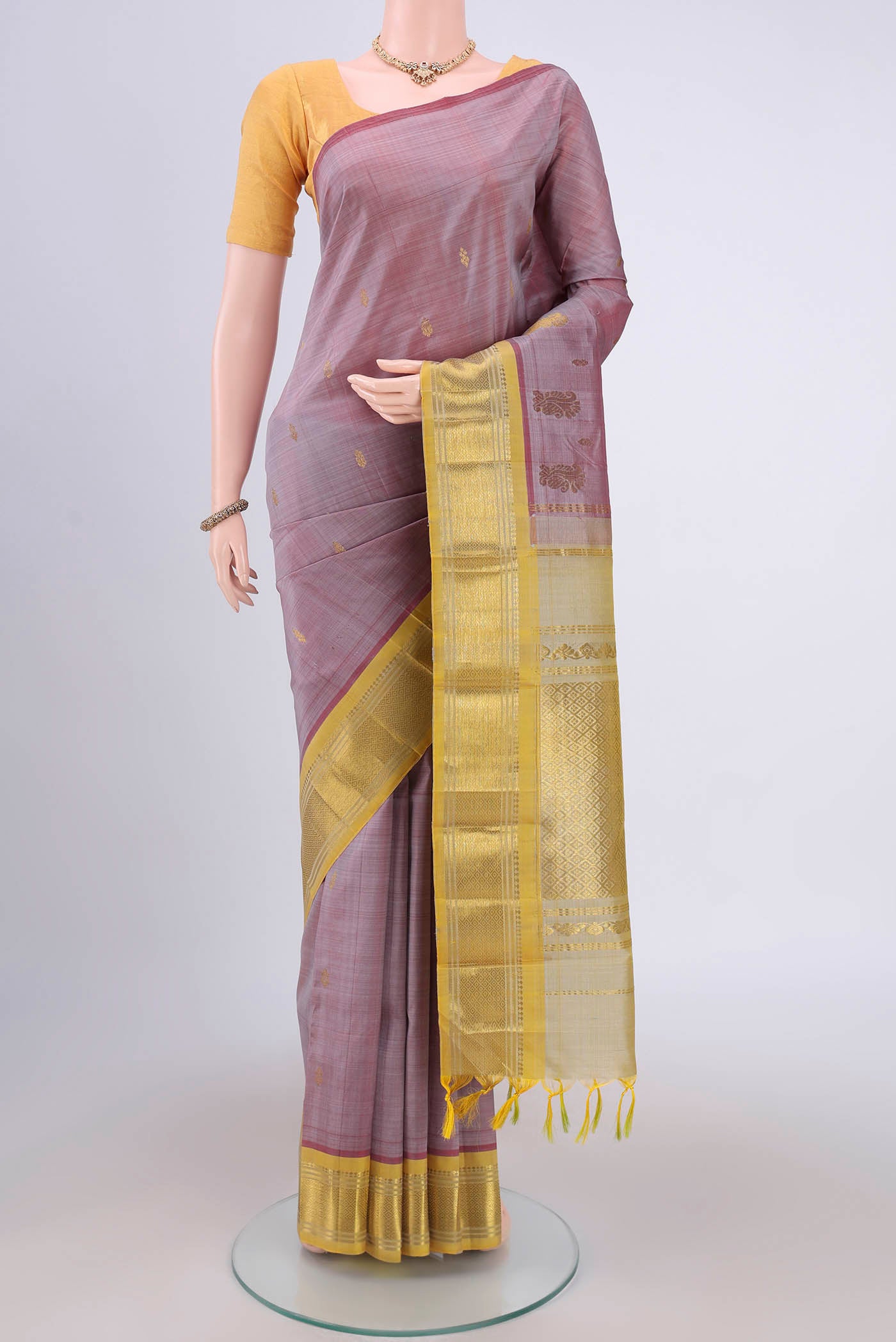 Coral Kanjivaram Silk Saree with Zari Butta on the body and One Side Border.  displayed on a mannequin