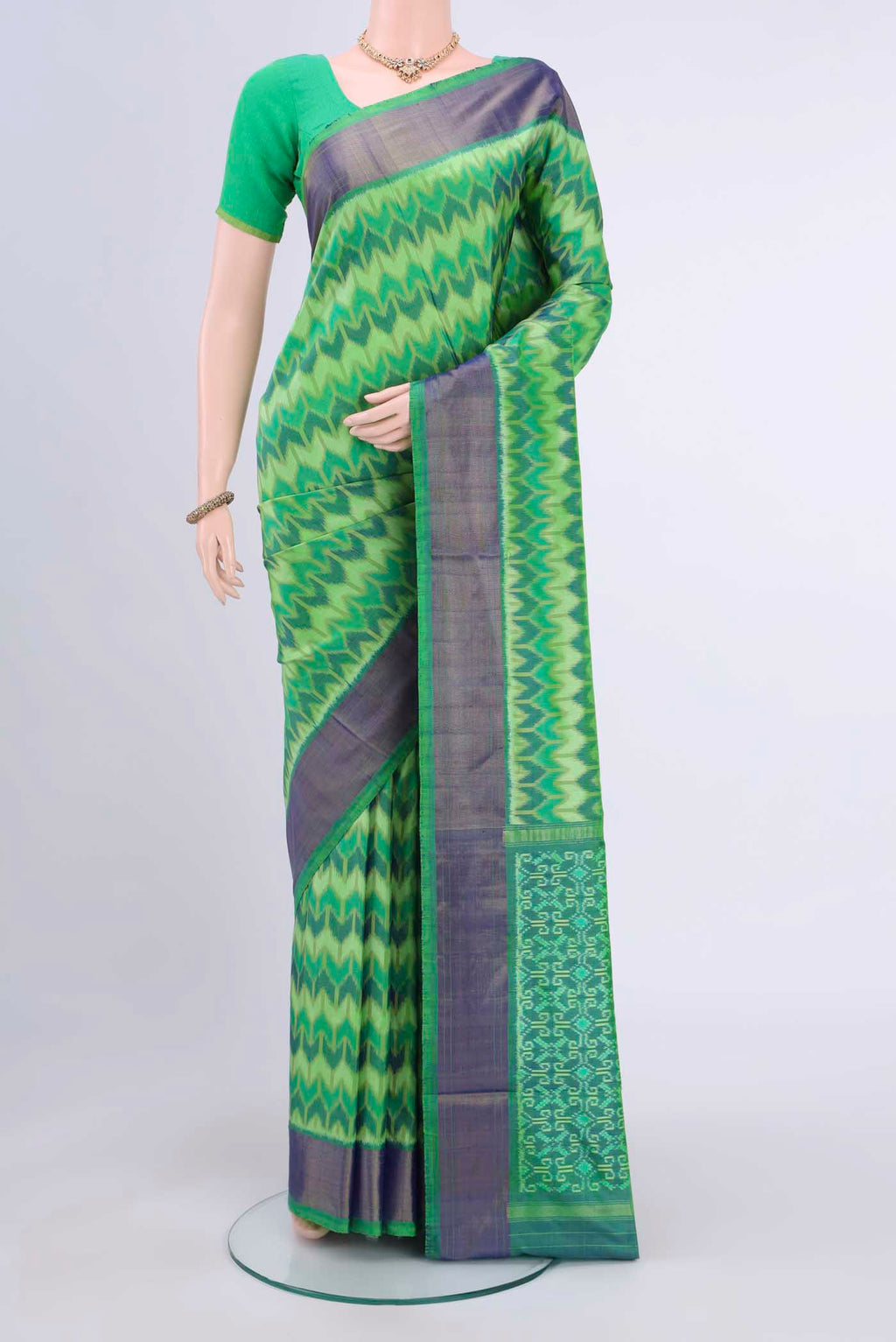 Mint Green Pochampally Saree with Ikat Print on the body and Ikat Border displayed on a mannequin