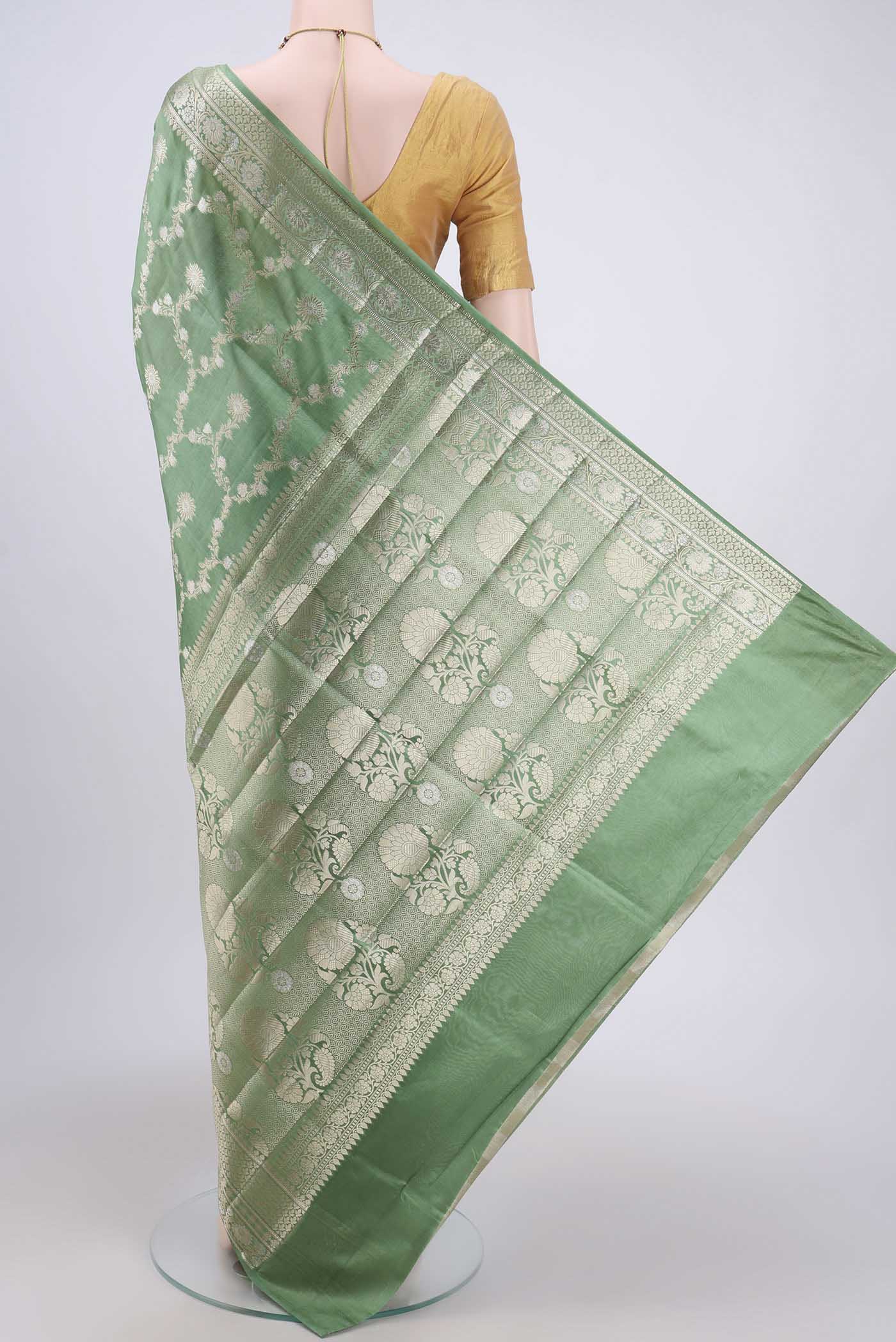 Flat view of Light Green Banarasi Raw Silk Saree with Zari Butta on the body and Zari Border. 