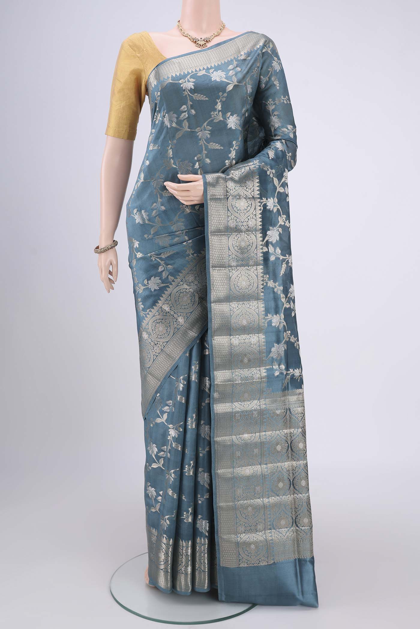 Maya Blue Banarasi Raw Silk Saree with Zari Butta on the body and Zari Border.  displayed on a mannequin