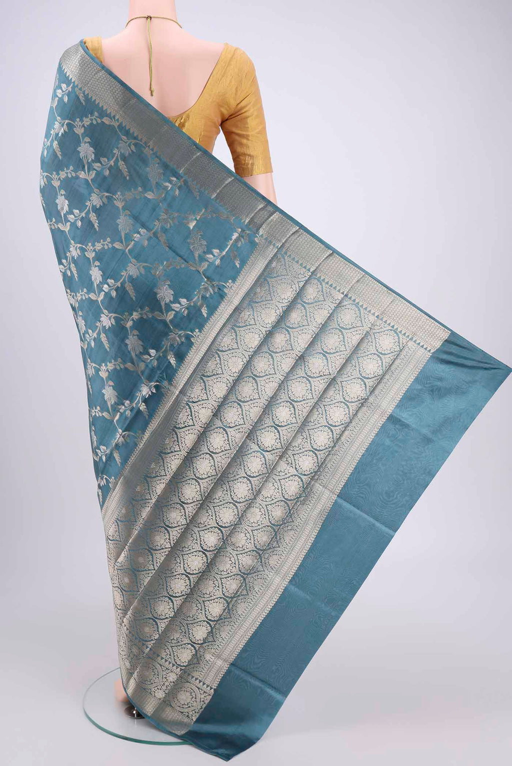 Flat view of Maya Blue Banarasi Raw Silk Saree with Zari Butta on the body and Zari Border. 