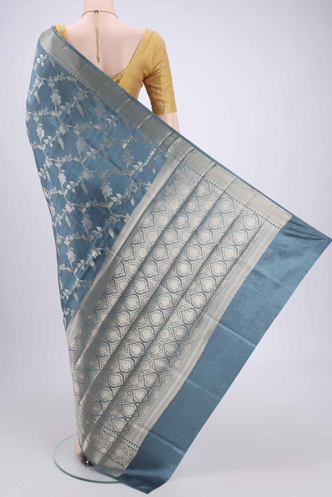 Flat view of Maya Blue Banarasi Raw Silk Saree with Zari Butta on the body and Zari Border. 