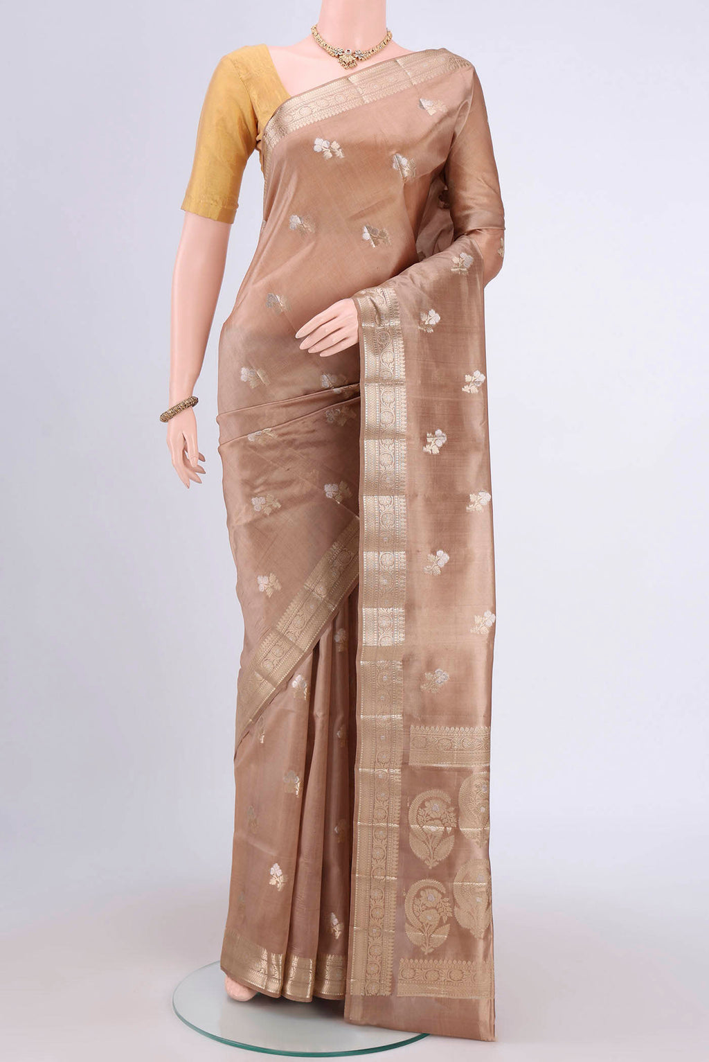 Beige Banarasi Raw Silk Saree with Zari Butta on the body and Zari Border.  displayed on a mannequin