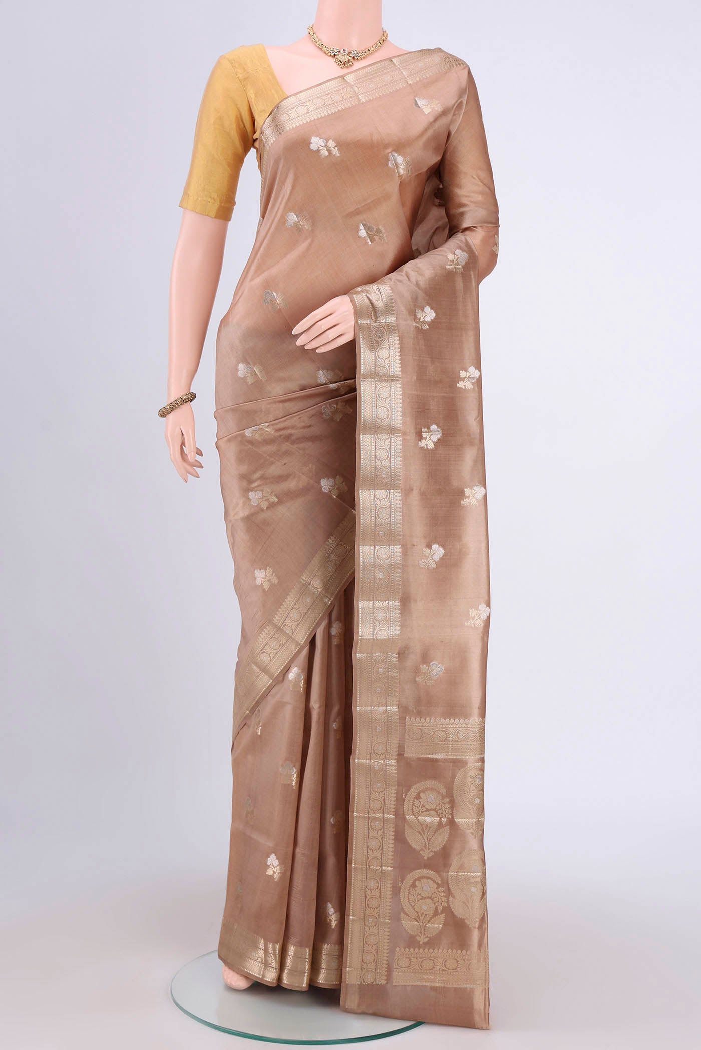 Beige Banarasi Raw Silk Saree with Zari Butta on the body and Zari Border.  displayed on a mannequin