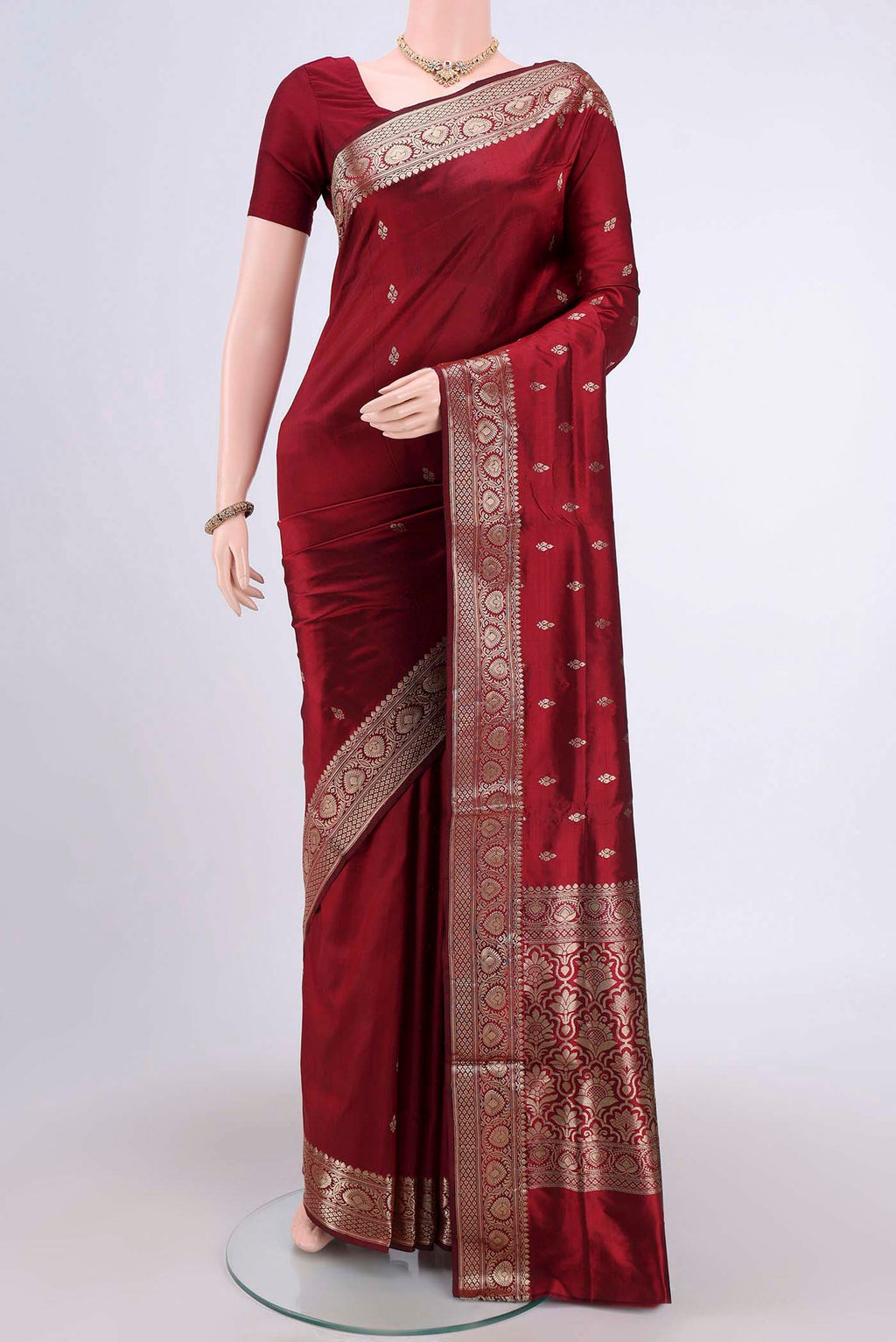 Maroon Banarasi Katan Silk Saree with Zari Butta on the body and Zari Border.  displayed on a mannequin
