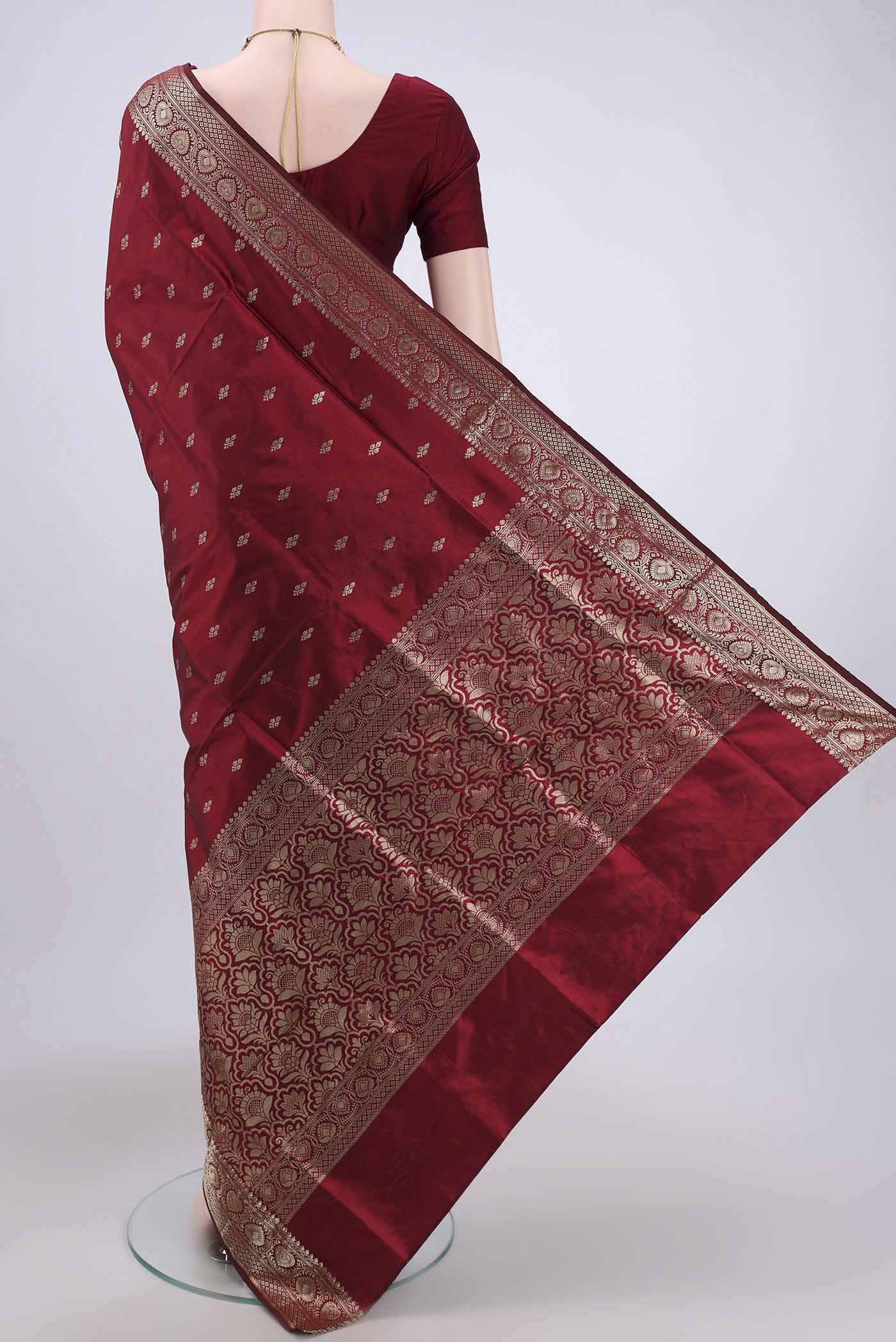 Flat view of Maroon Banarasi Katan Silk Saree with Zari Butta on the body and Zari Border. 