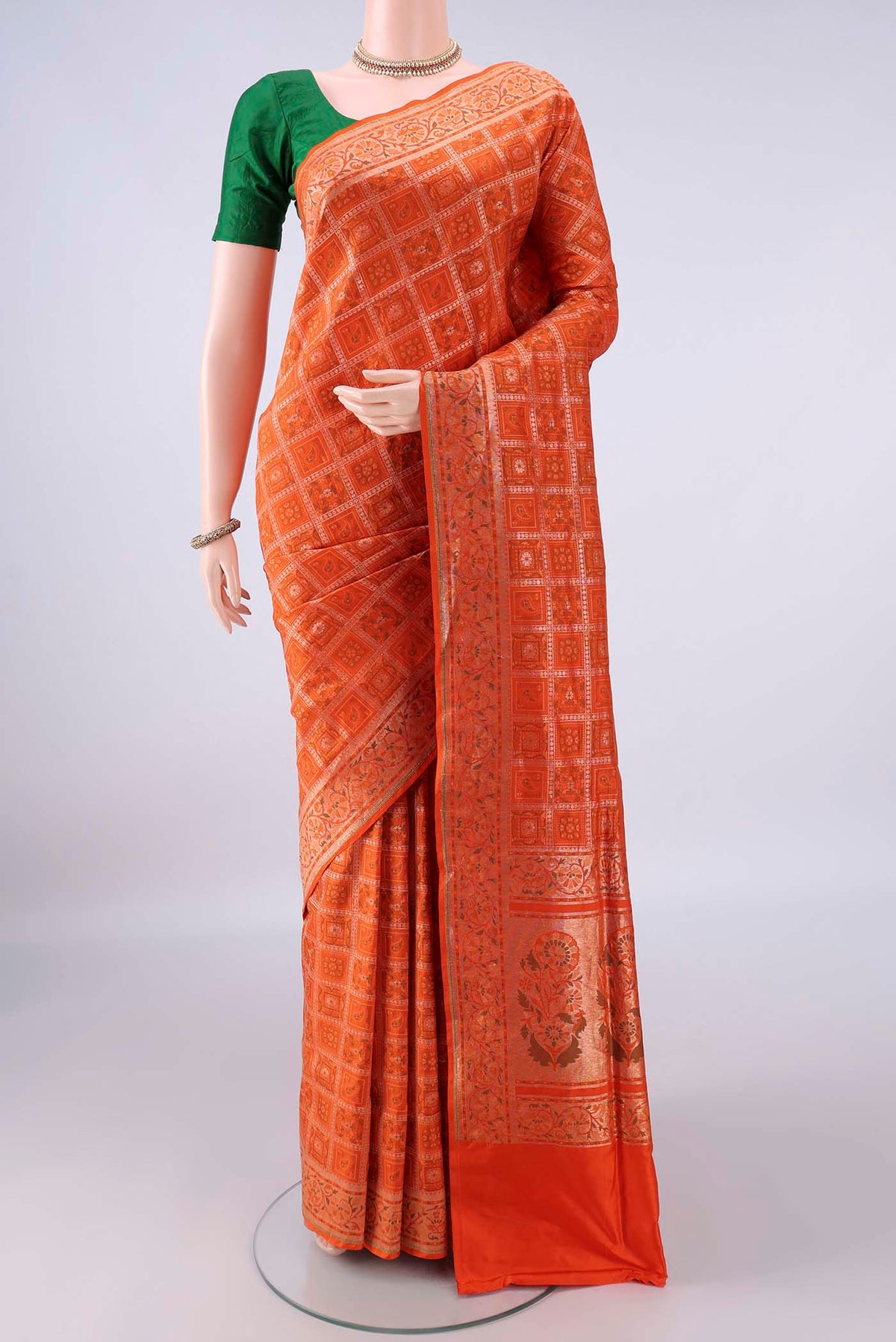 Pure Silk Orange Banarasi Jamavar Saree with Checked design on the body and Zari Border.  displayed on a mannequin