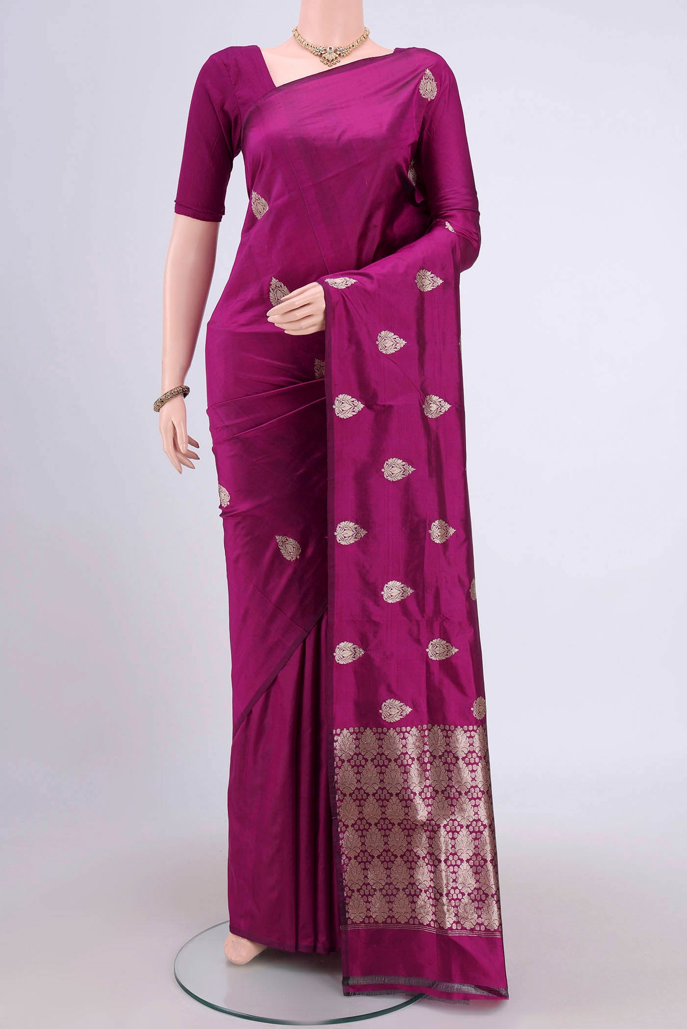 Magenta Banarasi Katan Silk Saree with Zari Butta on the body and Without Border.  displayed on a mannequin