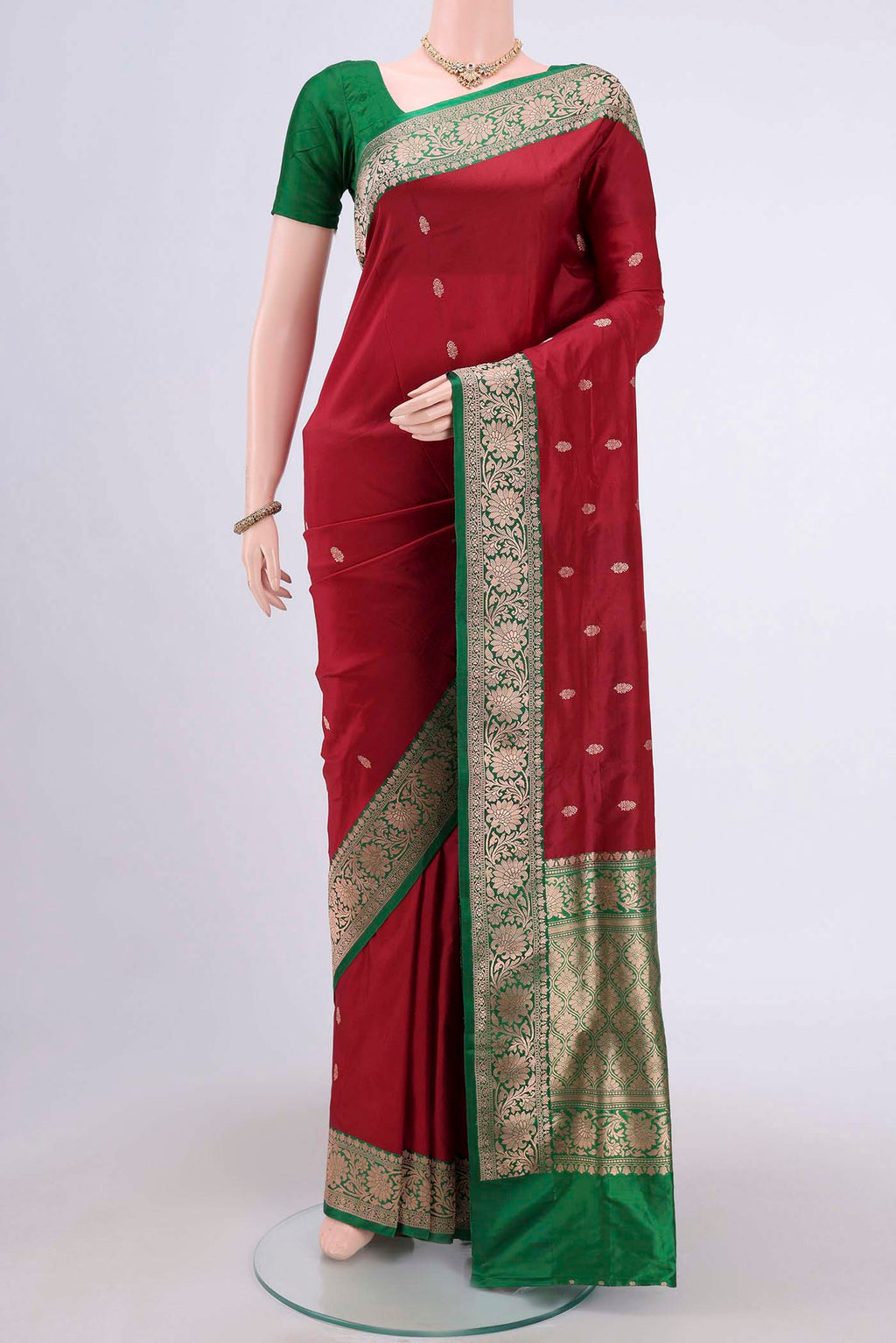 Maroon Banarasi Katan Silk Saree with Zari Butta on the body and Zari Border.  displayed on a mannequin