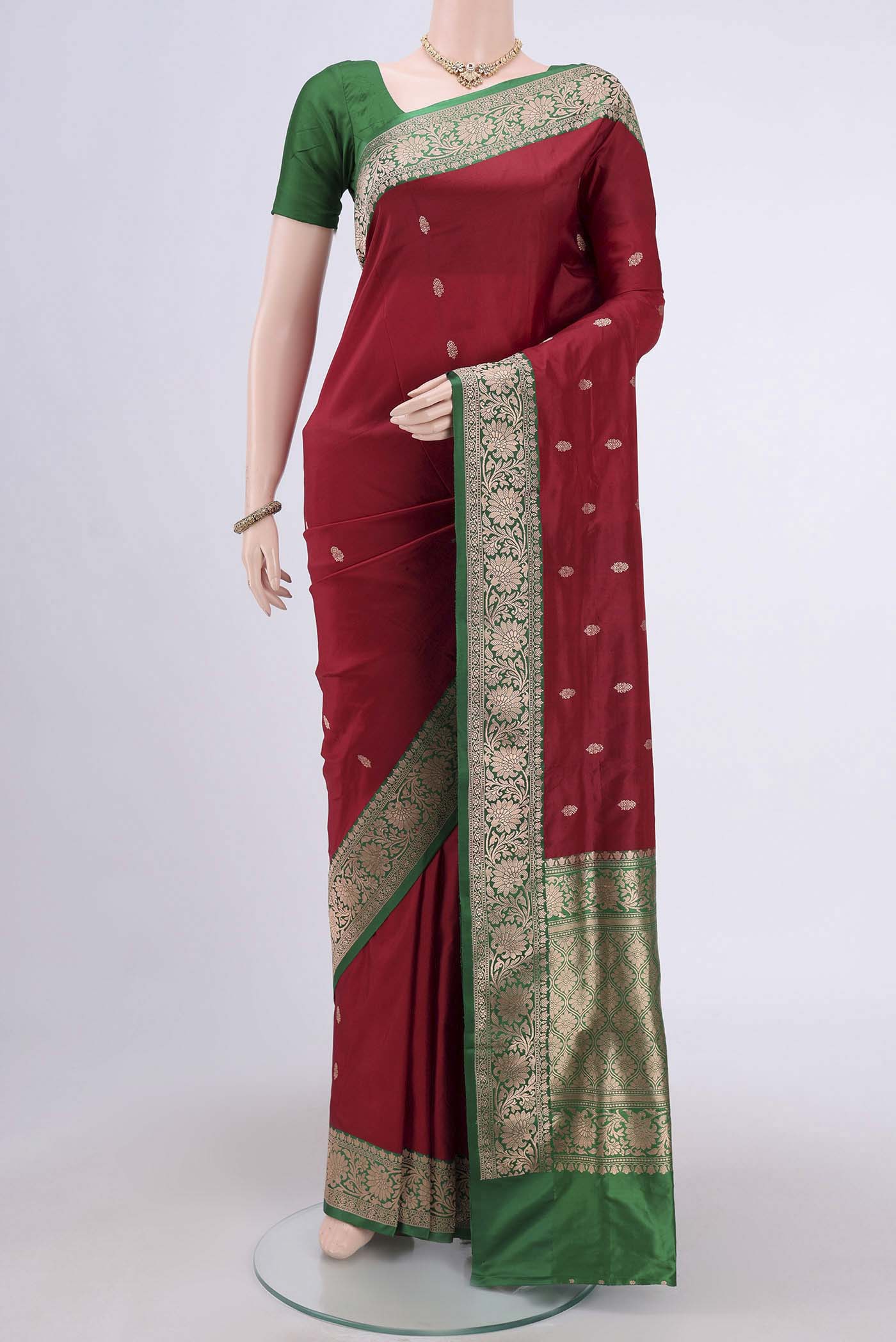 Maroon Banarasi Katan Silk Saree with Zari Butta on the body and Zari Border.  displayed on a mannequin