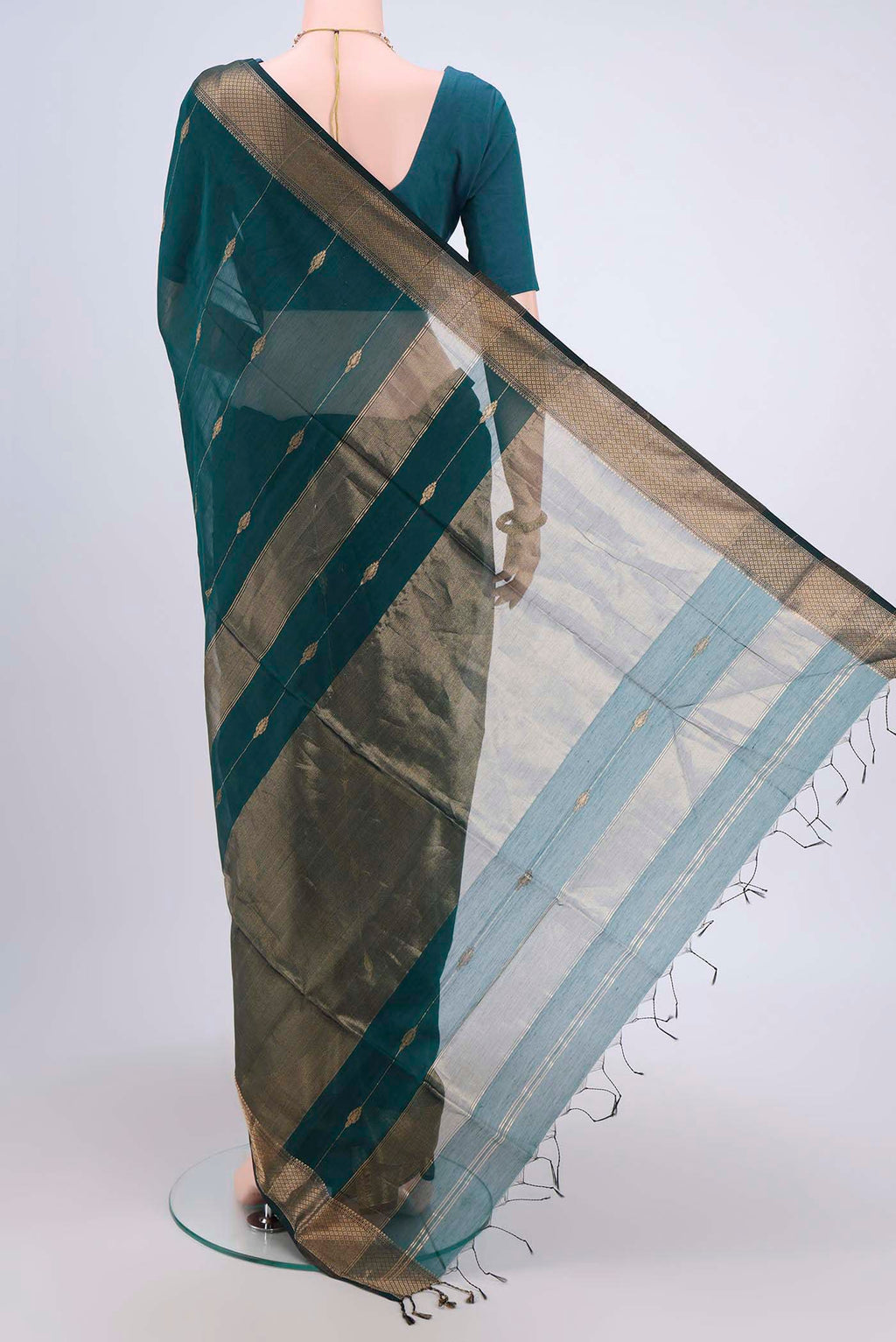 Flat view of Peacock Blue Maheshwari Silk Cotton Saree with Zari Butta on the body and Zari Border. 
