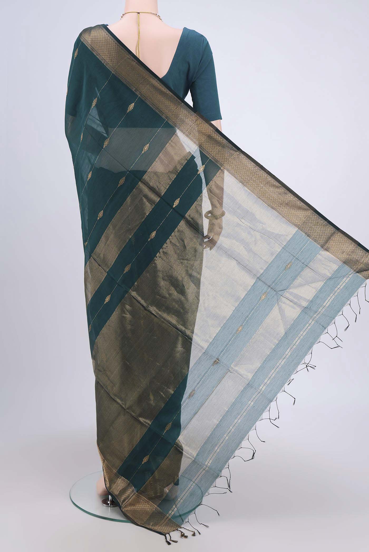 Flat view of Peacock Blue Maheshwari Silk Cotton Saree with Zari Butta on the body and Zari Border. 