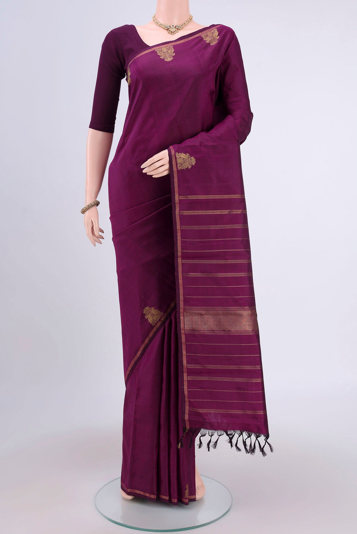 Pure Silk Pure Zari Purple Kanjivaram Saree with Zari Butta on the body and Thin Zari Line.  displayed on a mannequin