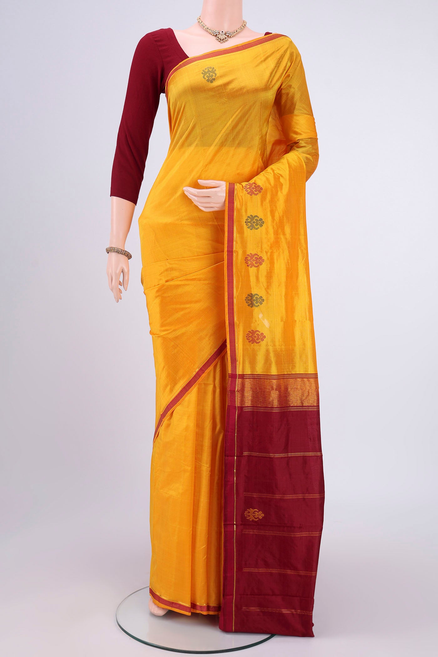 Yellow Kanchipuram Silk Saree with Plain Body and Zari And Thread Border.  displayed on a mannequin
