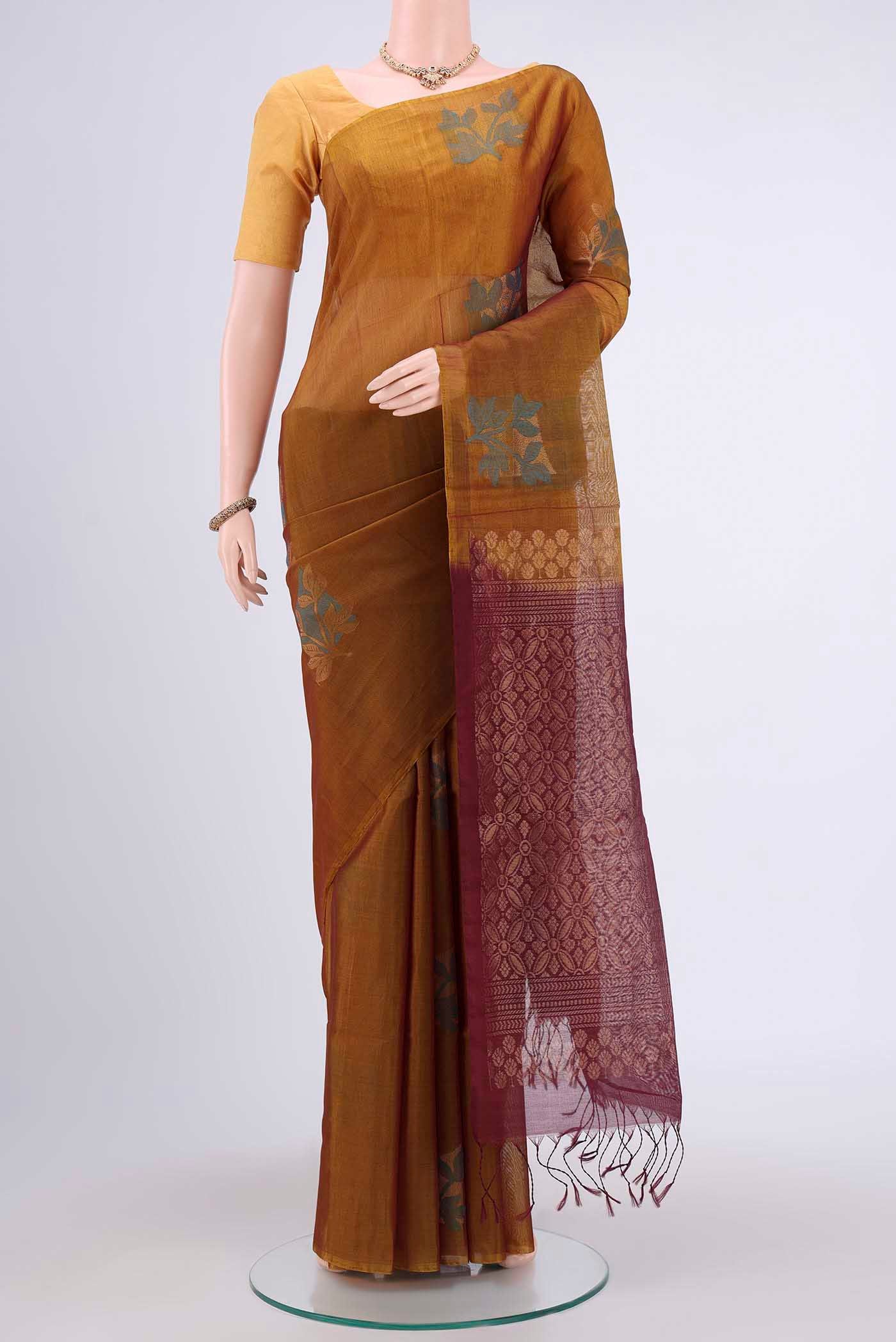 Mustard Kora Cotton Saree with Zari Butta on the body and Zari Border.  displayed on a mannequin