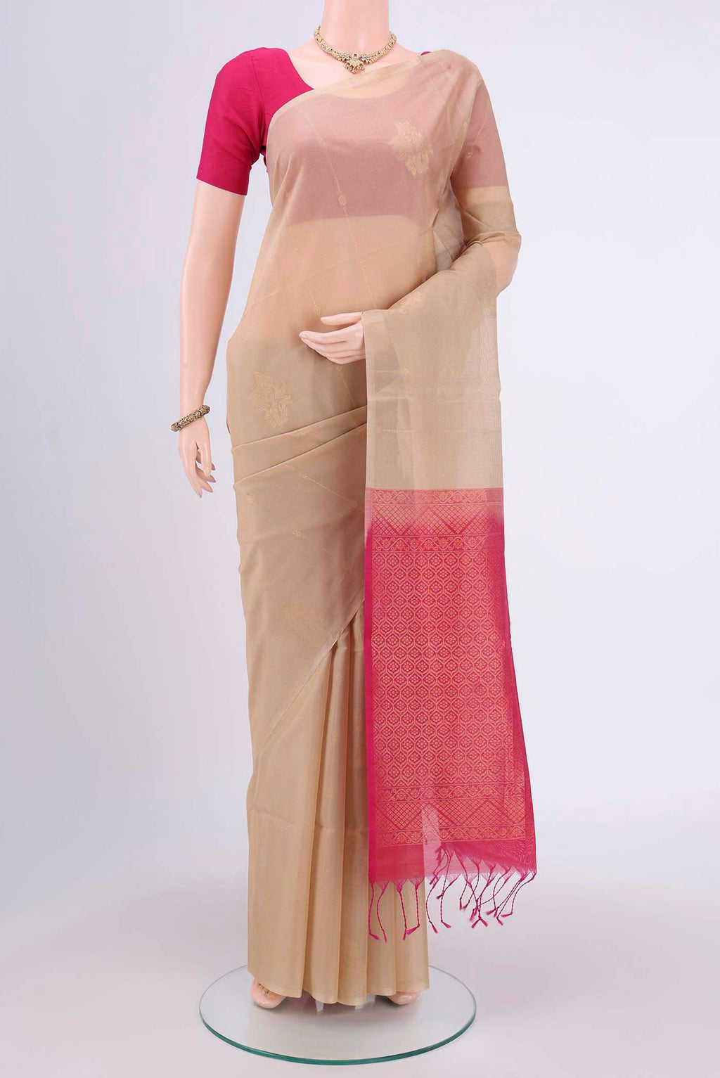 Beige Kora Cotton Saree with Zari Butta on the body and Zari Border.  displayed on a mannequin