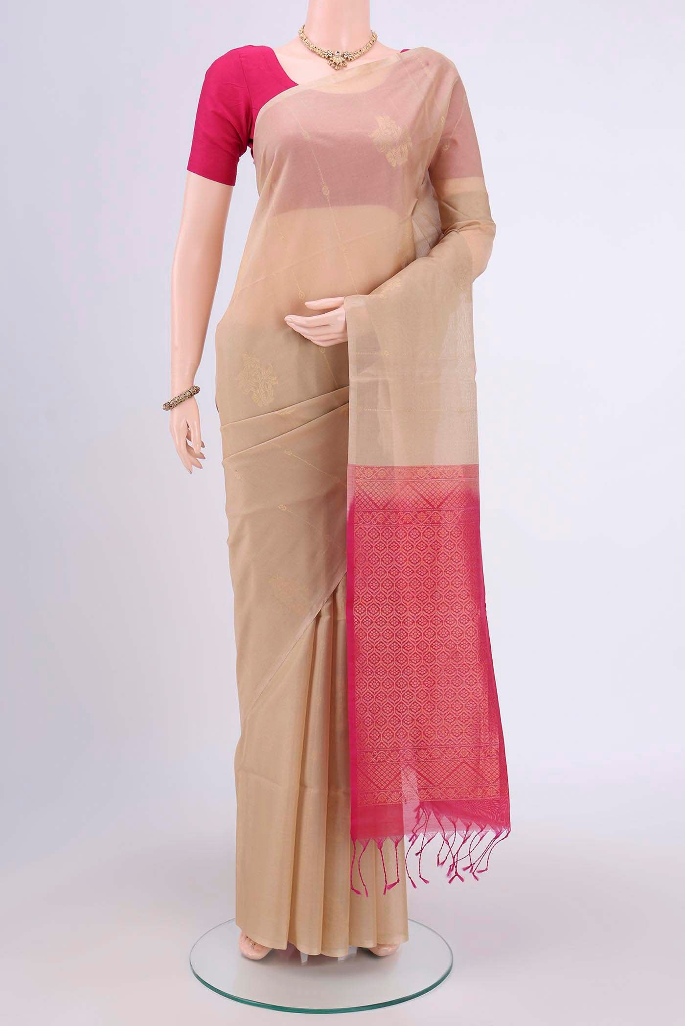 Beige Kora Cotton Saree with Zari Butta on the body and Zari Border.  displayed on a mannequin