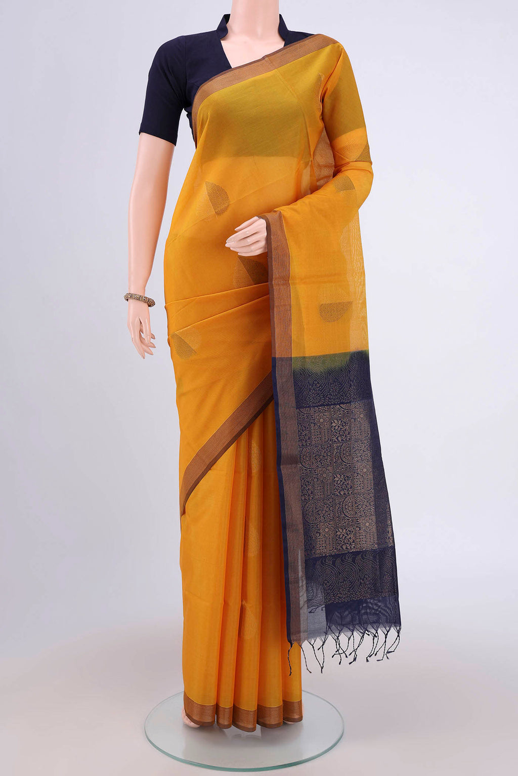 Mustard Kora Cotton Saree with Zari Butta on the body and Plain Border.  displayed on a mannequin