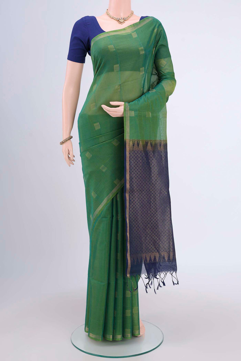 Green Kora Cotton Saree with Zari Butta on the body and Zari Border.  displayed on a mannequin