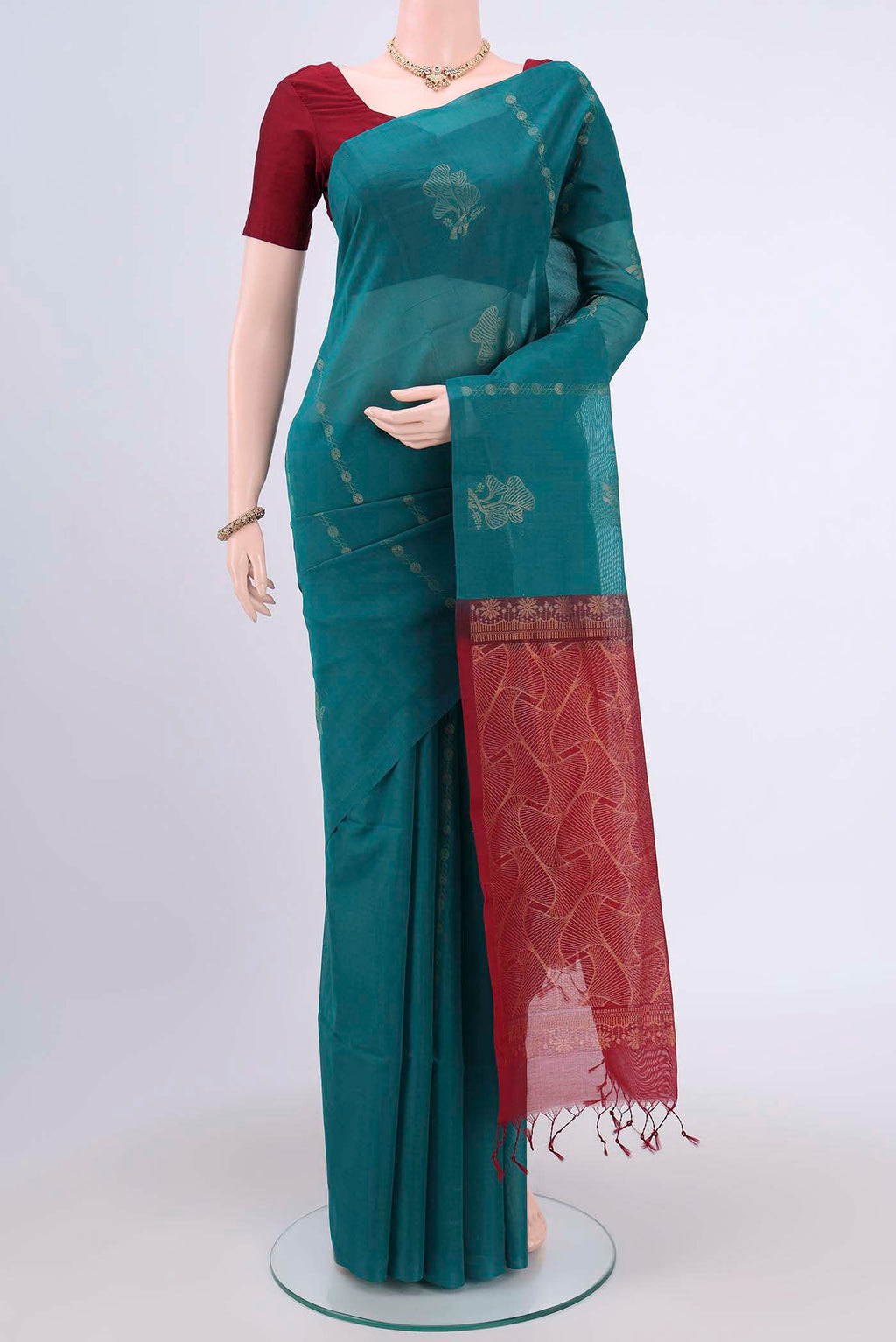 Sea Green Kora Cotton Saree with Zari Butta on the body and Zari Border.  displayed on a mannequin