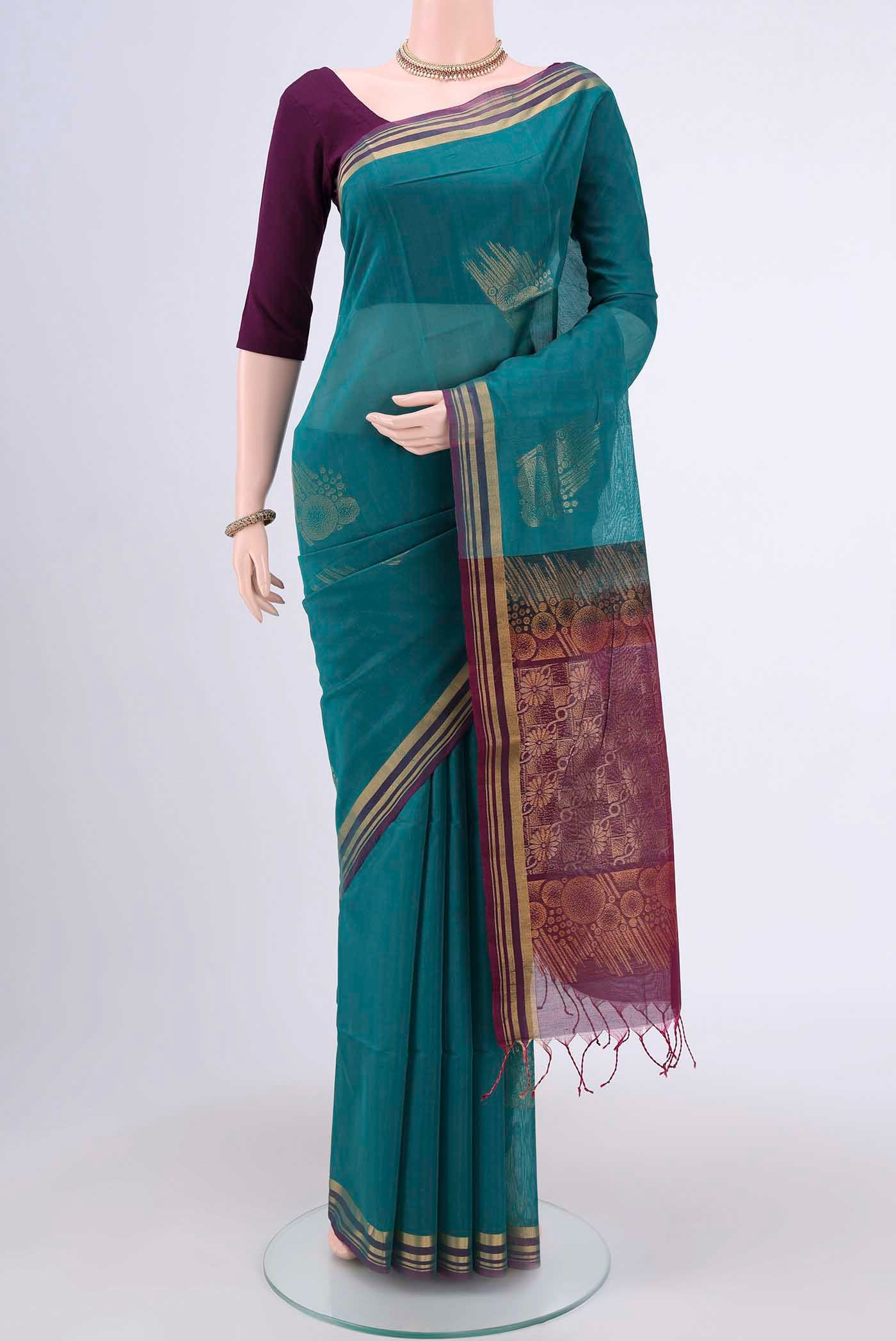 Sea Green Kora Cotton Saree with Zari Butta on the body and Zari Border.  displayed on a mannequin