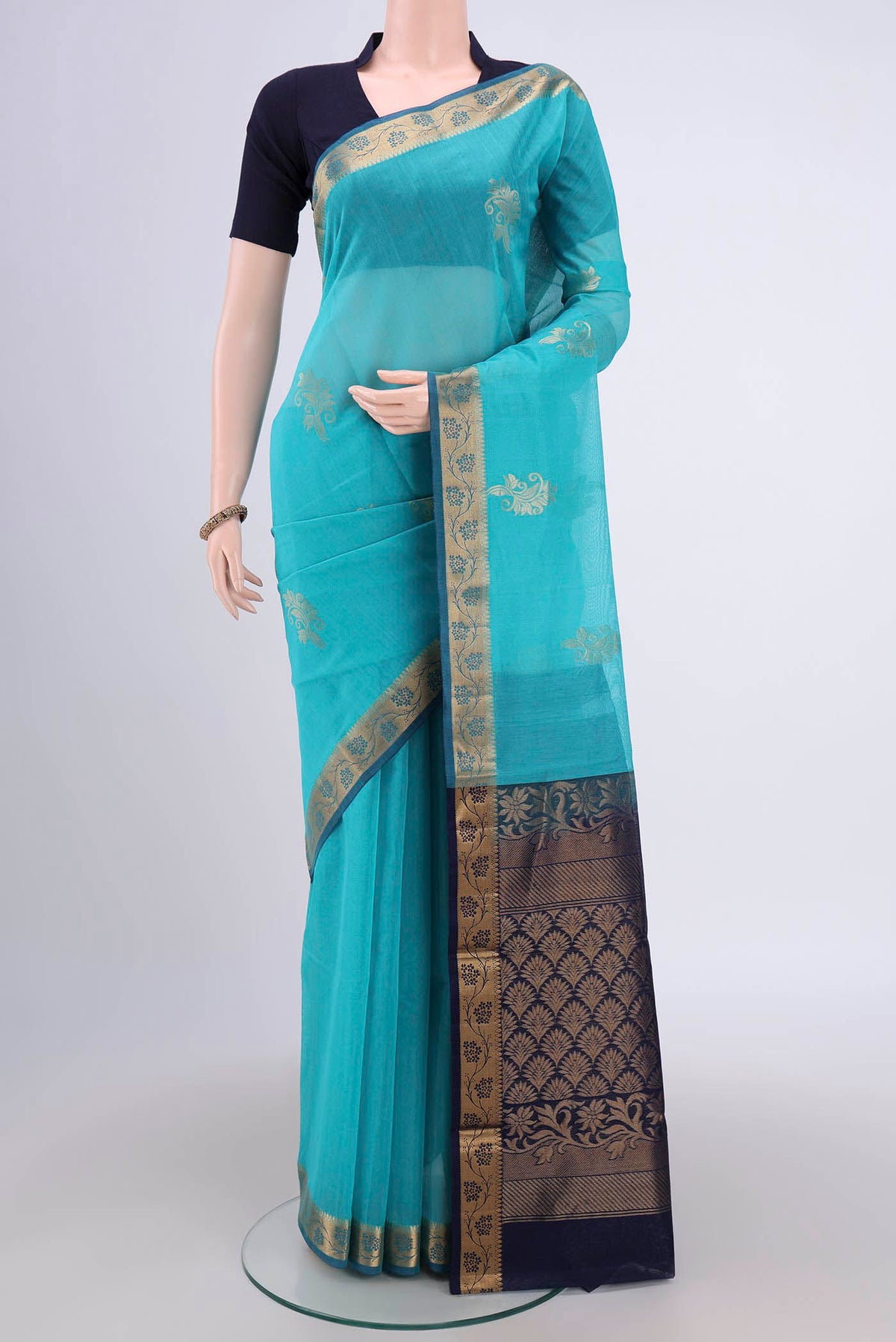 Turquoise Silk Cotton Saree with Zari Butta on the body and Zari Border.  displayed on a mannequin