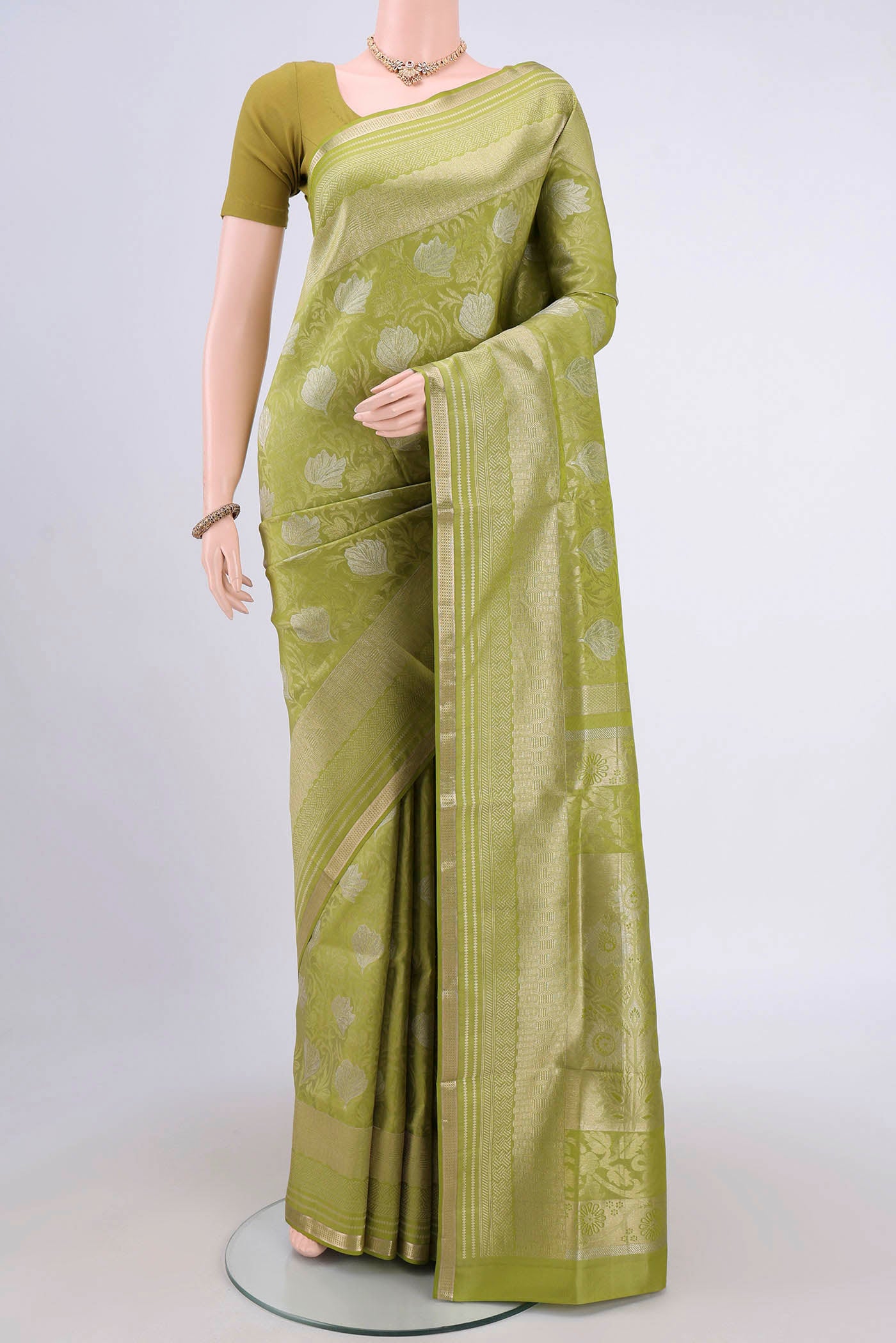 Light Green Soft Silk Saree with Zari Brocade on the body and Zari Border.  displayed on a mannequin