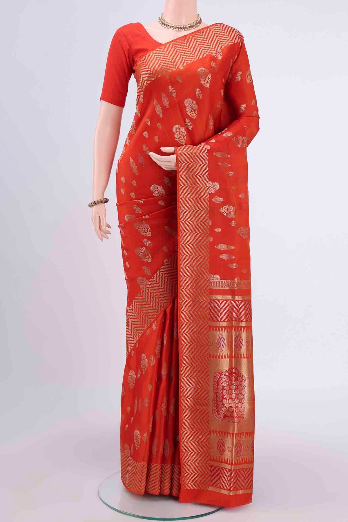 Orange Soft Silk Saree with Zari Butta on the body and Zari Border displayed on a mannequin