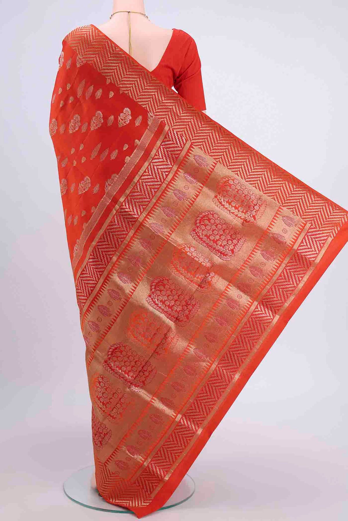 Flat view of Orange Soft Silk Saree with Zari Butta on the body and Zari Border