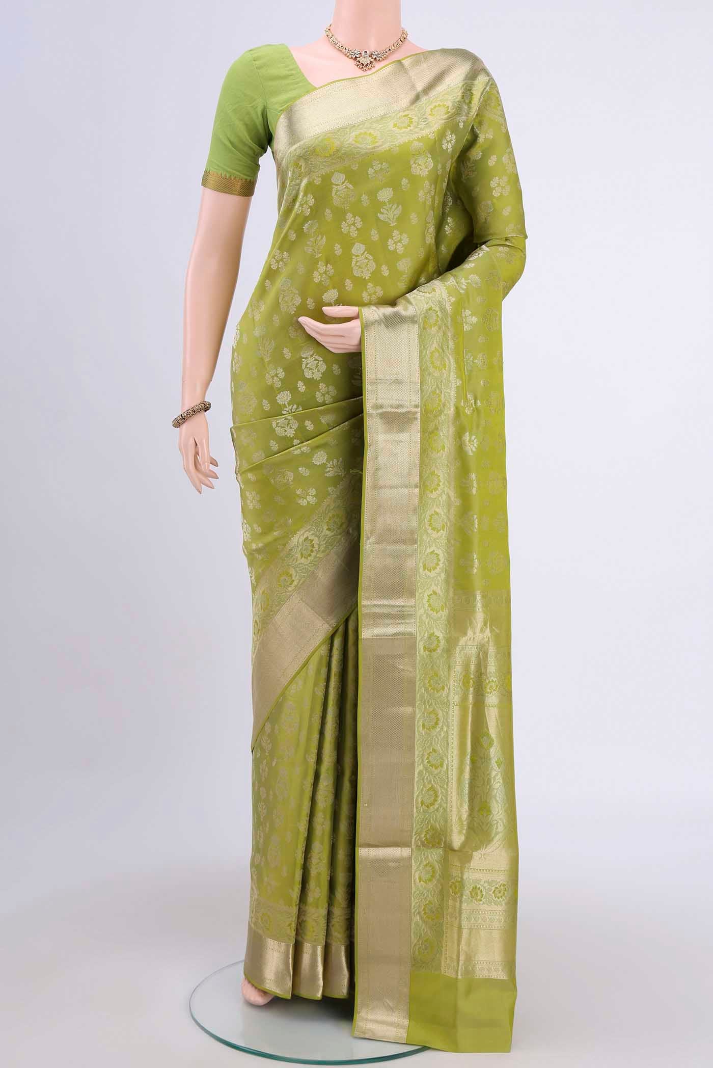 Light Green Soft Silk Saree with Zari Butta on the body and Zari Border displayed on a mannequin